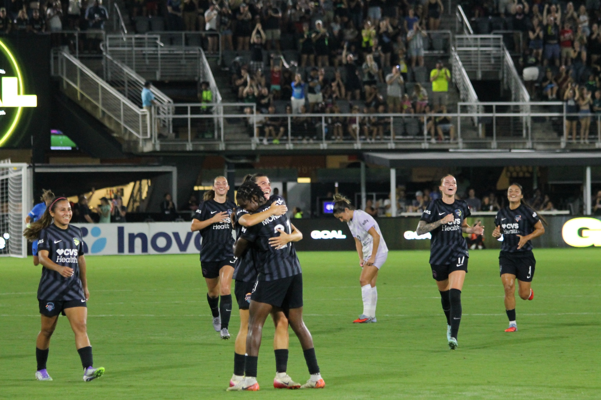 Sofia Cantore hugs Gift Monday as Washington Spirit teammates run to join the celebration after Cantore's first career NWSL goal