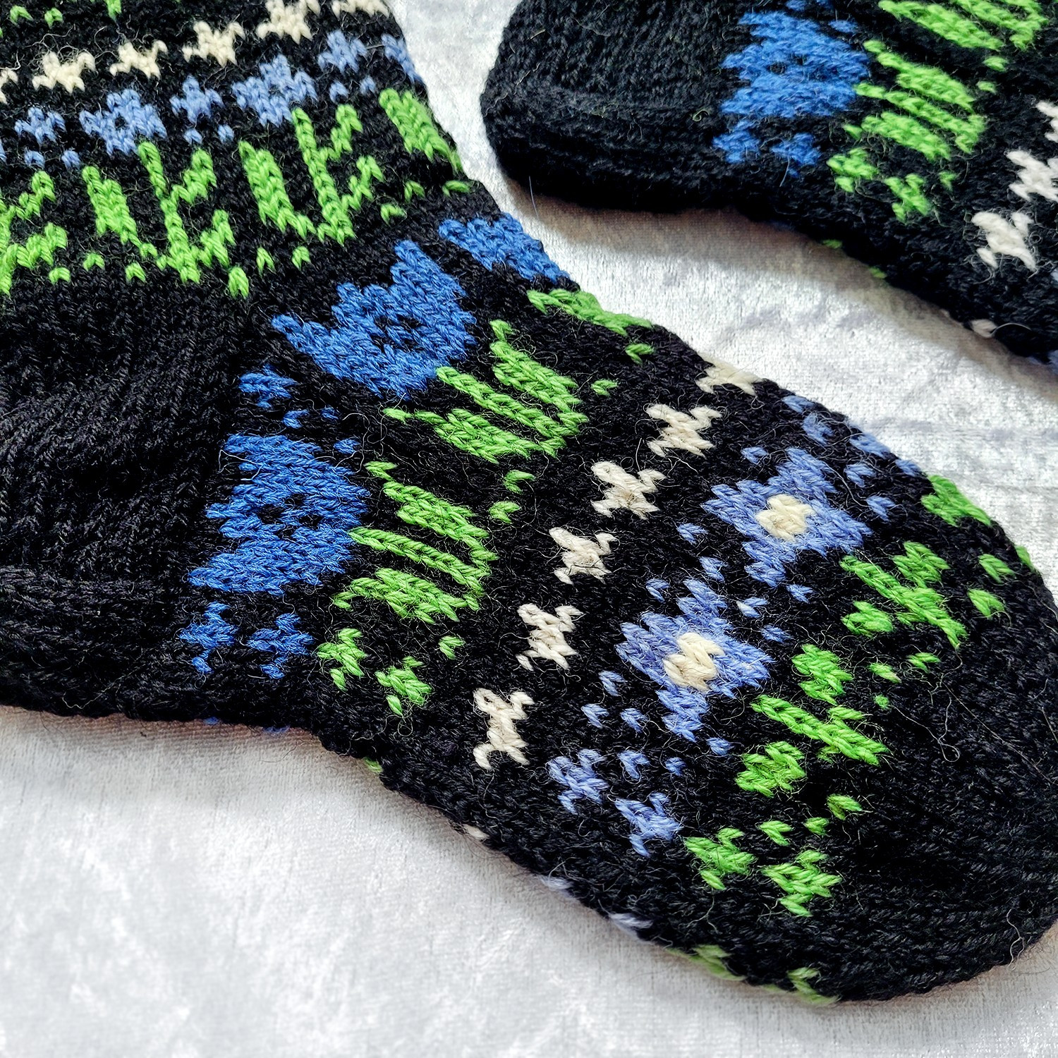 a detail shot of the knee-high socks' instep and sole, featuring three different types of flowers.