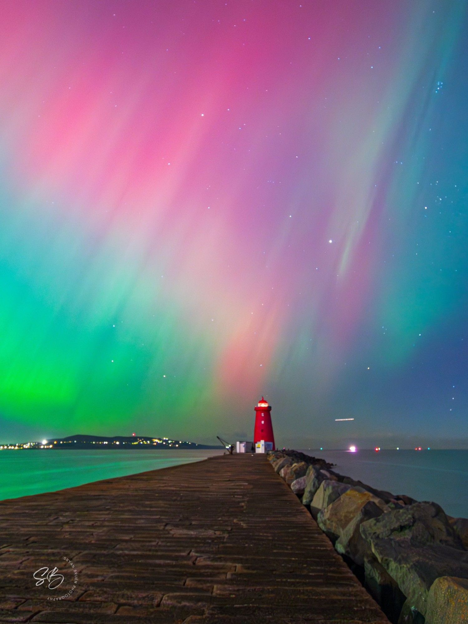 Stunning photo of the Northern Lights over Poolbeg Lighthouse in Dublin last night. Photo by Sryan Bruen. Entire sky is lit up with a vast rainbow of fluorescent colours streaking above the old red lighthouse at the edge of Dublin Bay.