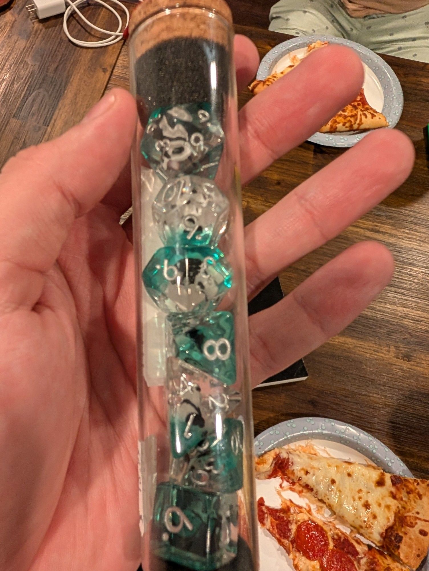 Clear teal dice with plastic pandaa in them .