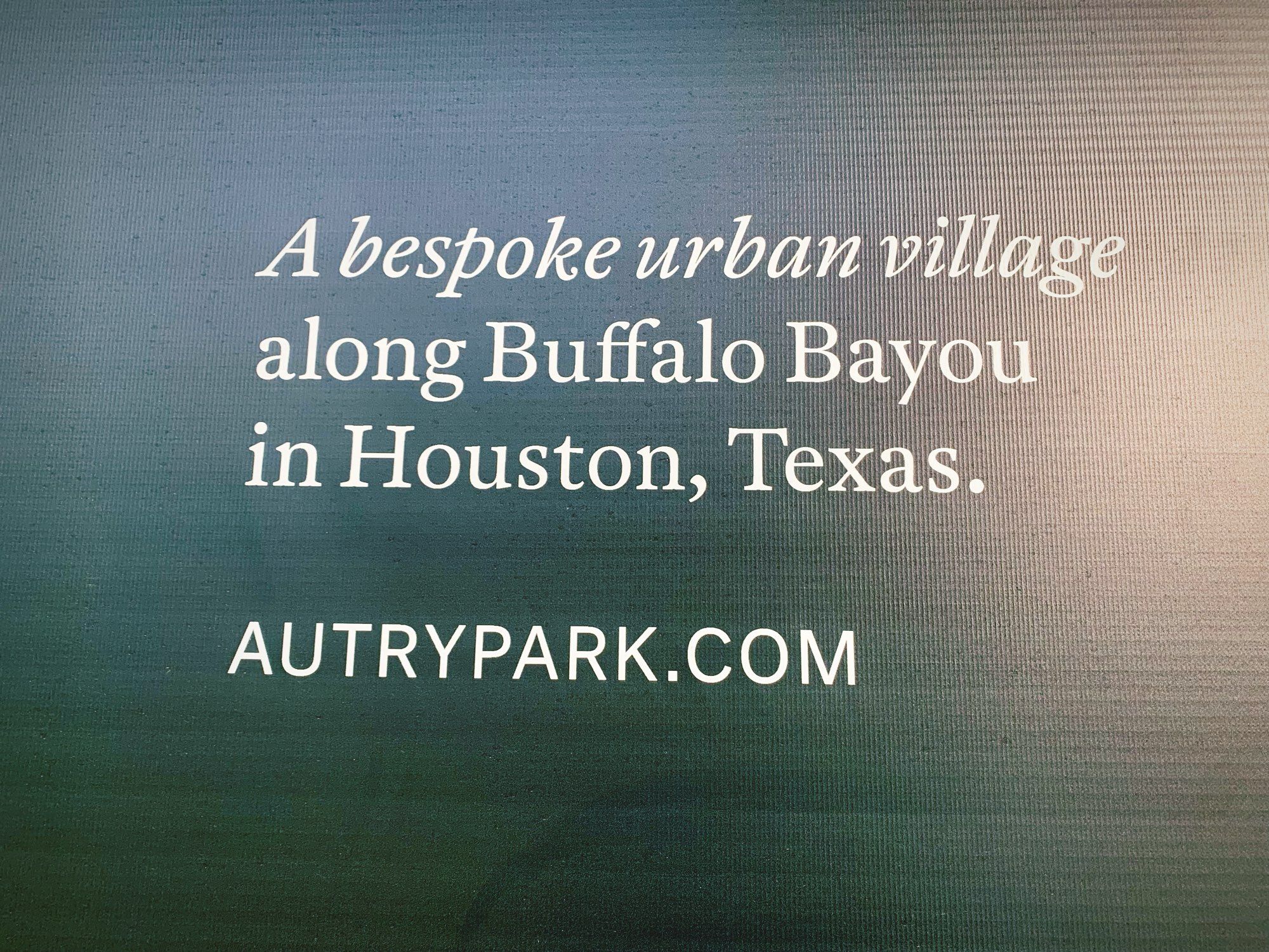 A sign reading, “A bespoke urban village along Buffalo Bayou in Houston, Texas.”