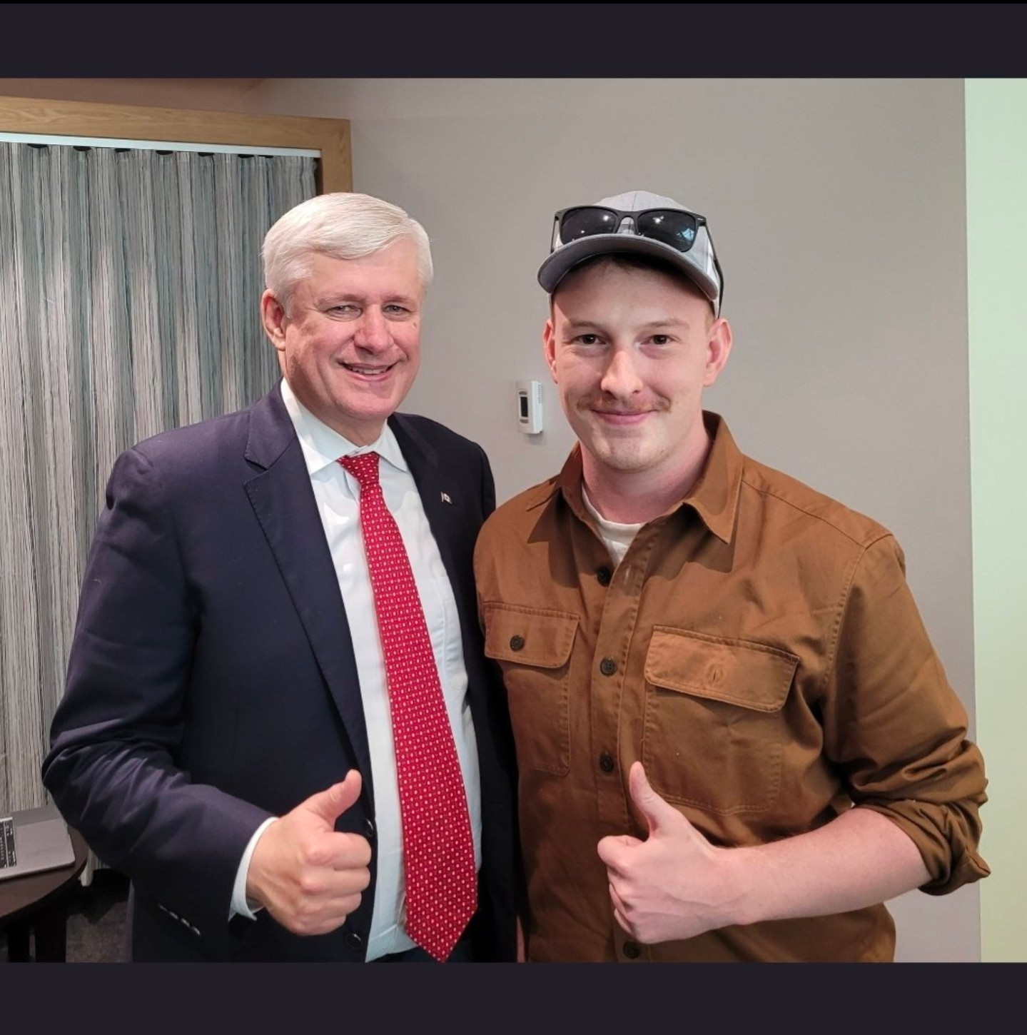 Keean Bexte and Stephen Harper embracing and giving thumbs up, like two greasy inbred weasels.