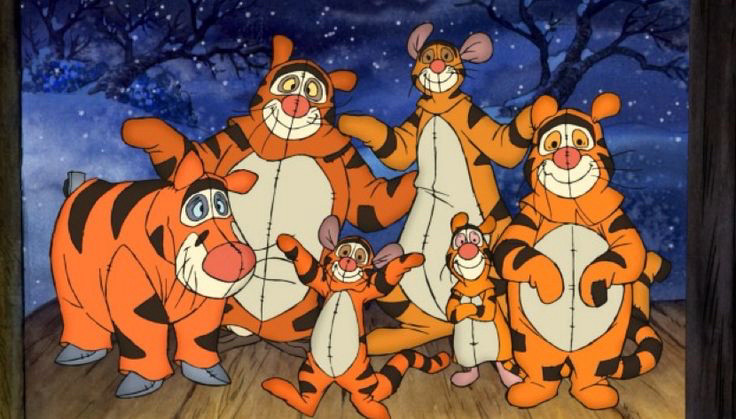 Eeyore (blue/grey donkey), Owl (brown/white owl), Pooh (yellow/orange Teddy bear), Kanga (female kangaroo) , Roo (brown Joey) & piglet (pink piglet) all dressed as tigger (orange with black stripes) standing on porch/deck outside doorway in front of snowy and leafless trees.