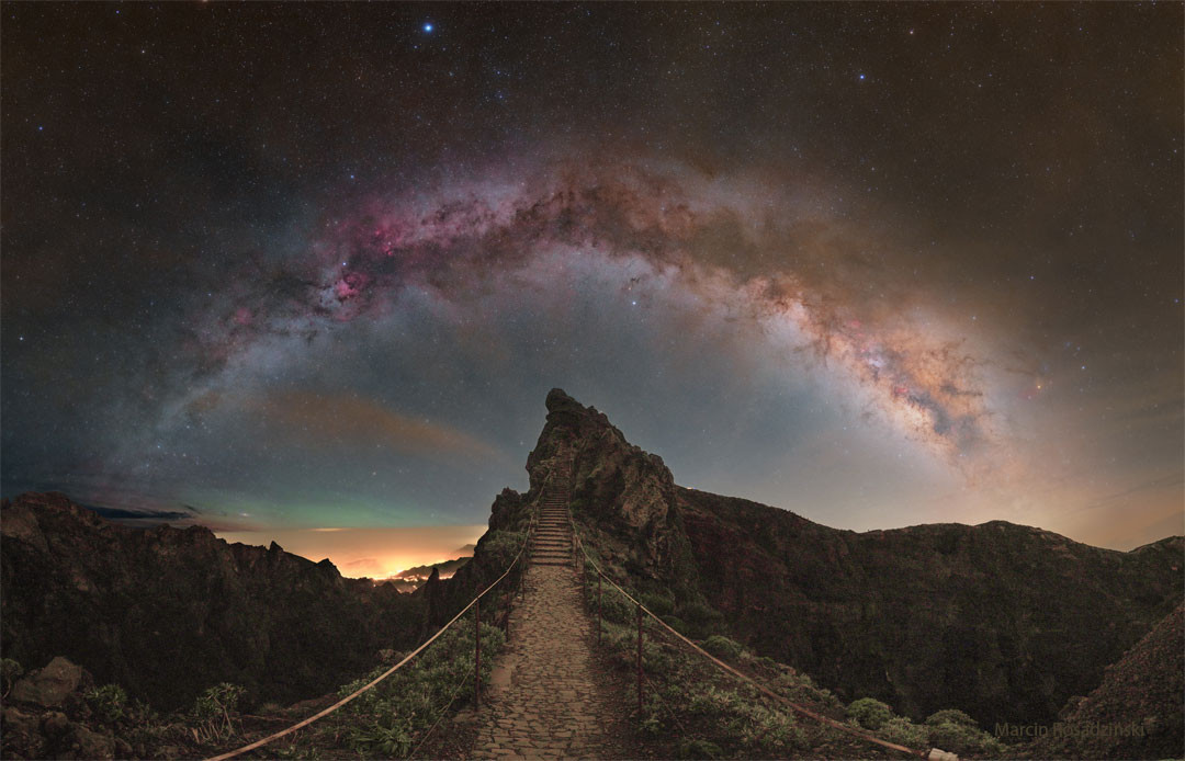 What happens if you ascend this stairway to the Milky Way? Before answering that, let's understand the beautiful sky you will see.  Most eye-catching is the grand arch of the Milky Way Galaxy, the band that is the central disk of our galaxy which is straight but distorted by the wide-angle nature of this composite image.  Many stars well in front of the Milk Way will be visible, with the bright white star just below the stellar arch being Altair, and the bright blue star above it being Vega.  The air glows green on the left, just above the yellow cloud deck.  The featured image was taken last month on Portugal's Madeira Island in the North Atlantic Ocean.  Oh, and what happens after you reach the top of these stairs and admire the amazing sky is, quite probably, that you then descend down the stairs on the other side.   Your Sky Surprise: What picture did APOD feature on your birthday? (post 1995)