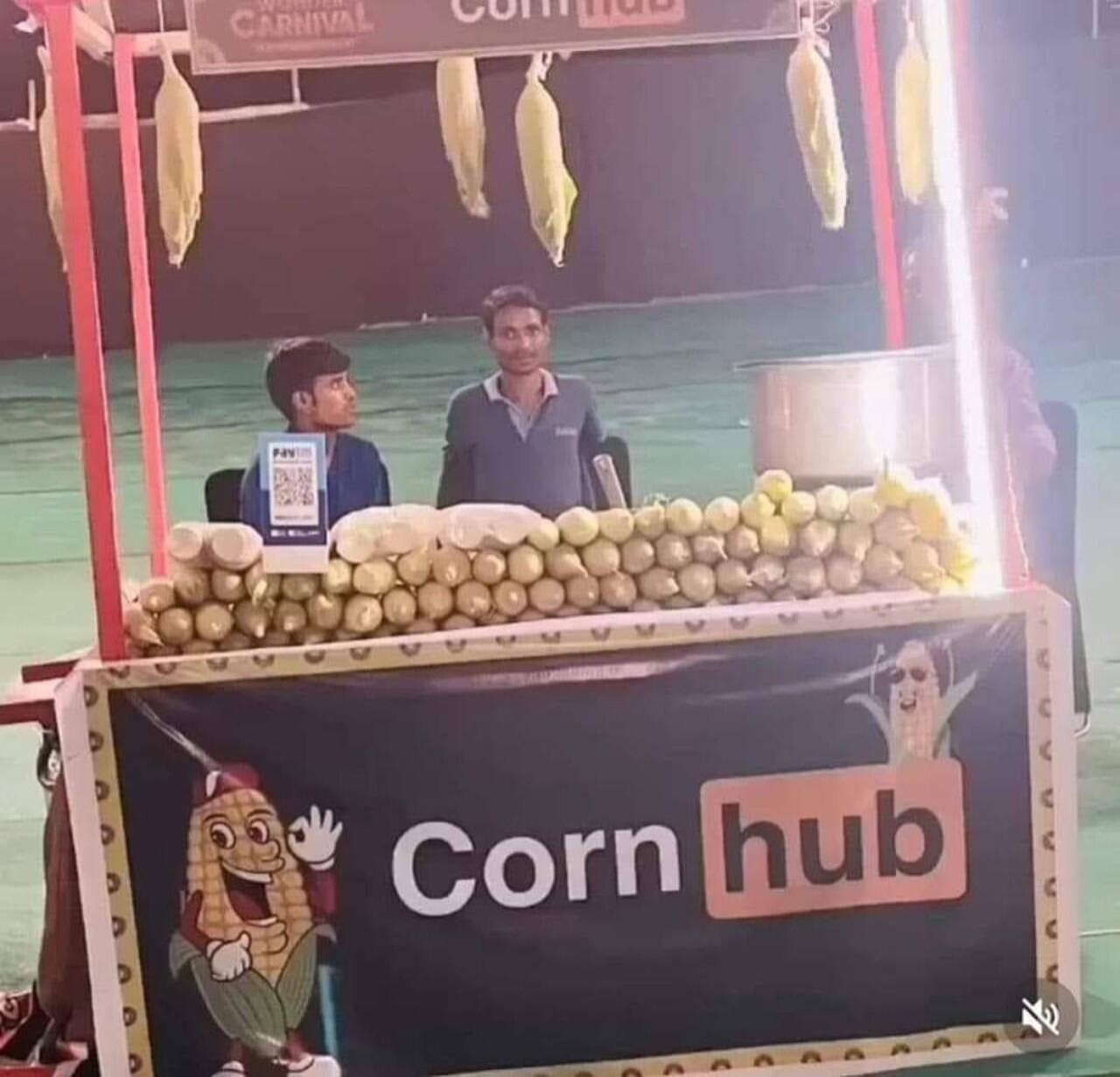 Puesto de mazorcas de maíz con el cartel Corn Hub imitando el logo de PornHub