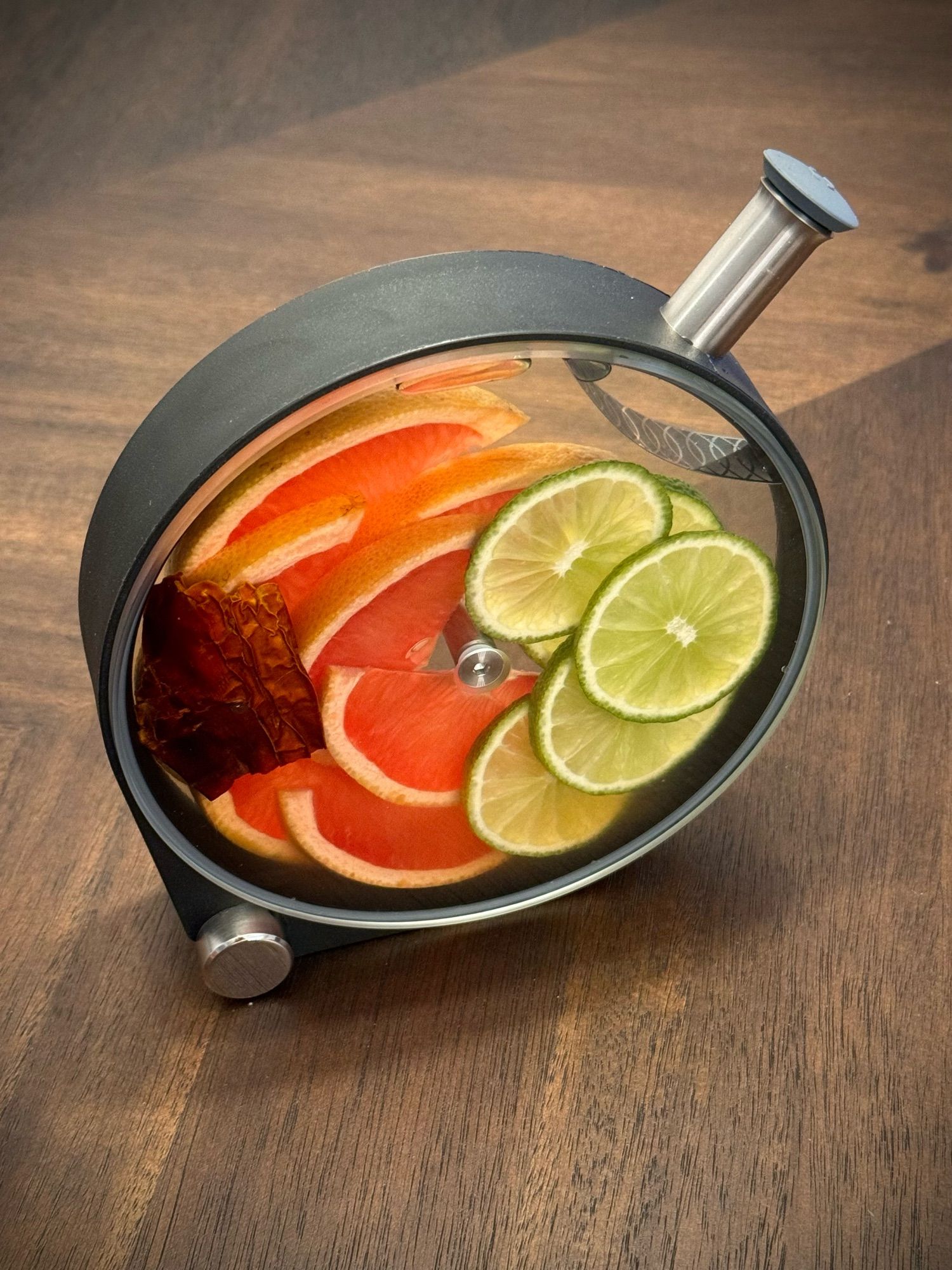 Fancy infuser with grapefruit, limes, and a chili filled with tequila.