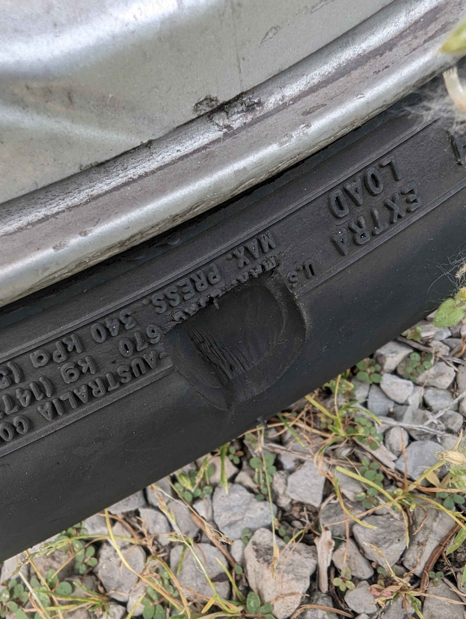 driver side tire with a large divot in the wall of the rubber