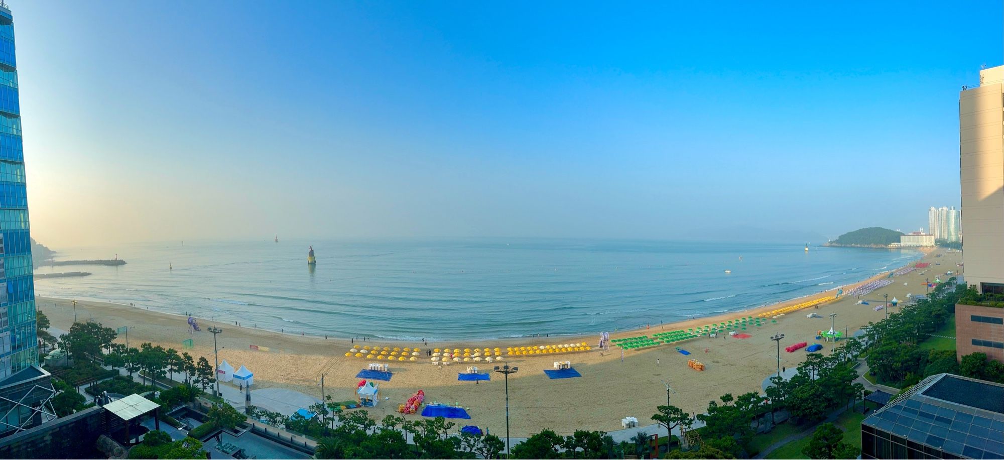 Panoramic view in early morning (with some sunshine) of the beach front, with a sandy beach, in Busan, South Korea.