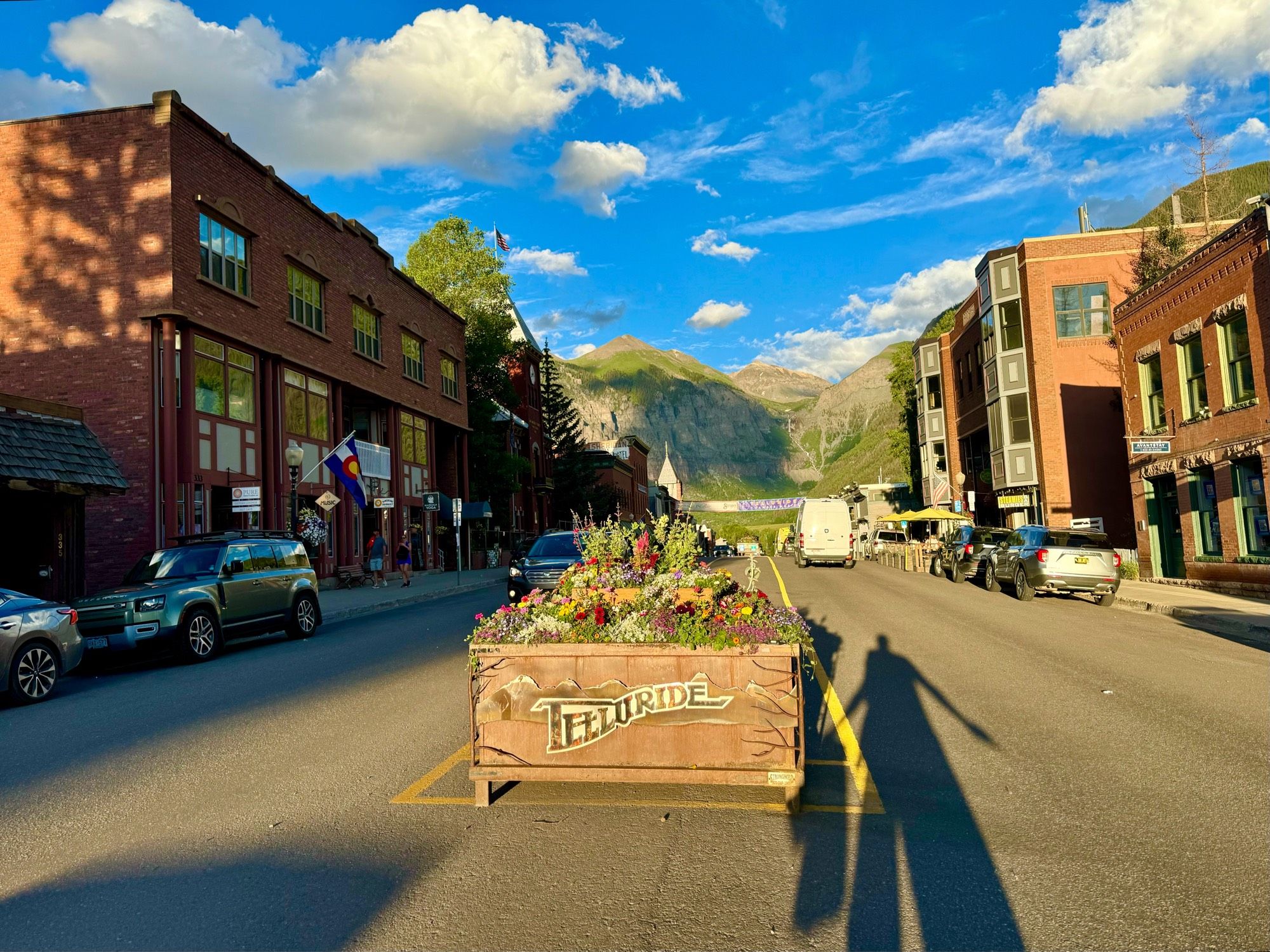 View down the main street of Telluride near sunset, with long shadows of me and my husband in foreground.