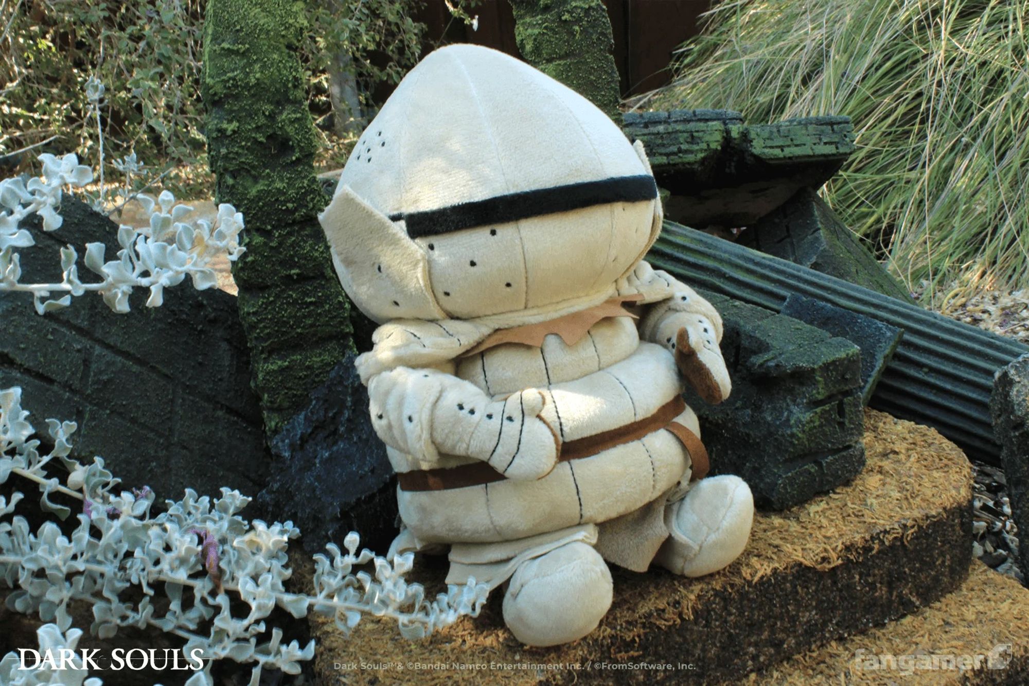 A Siegmeyer plush with embroidered details and fabric belt sits outdoors on a miniature set made to look like moss-covered steps and ruined columns.