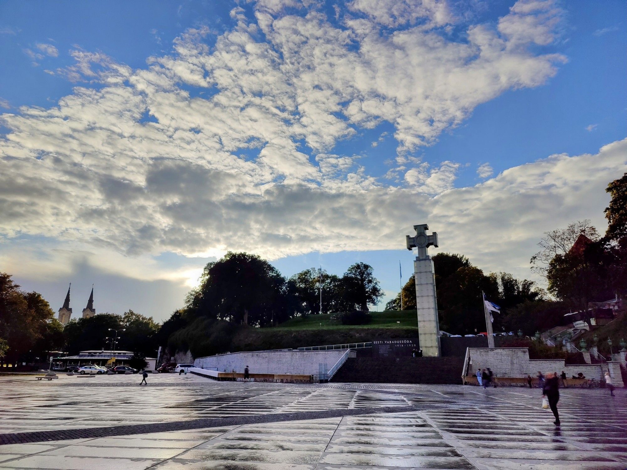 A photo of the sun shining through broken clouds over Vabaduse väljak in Tallinn, Estonia.