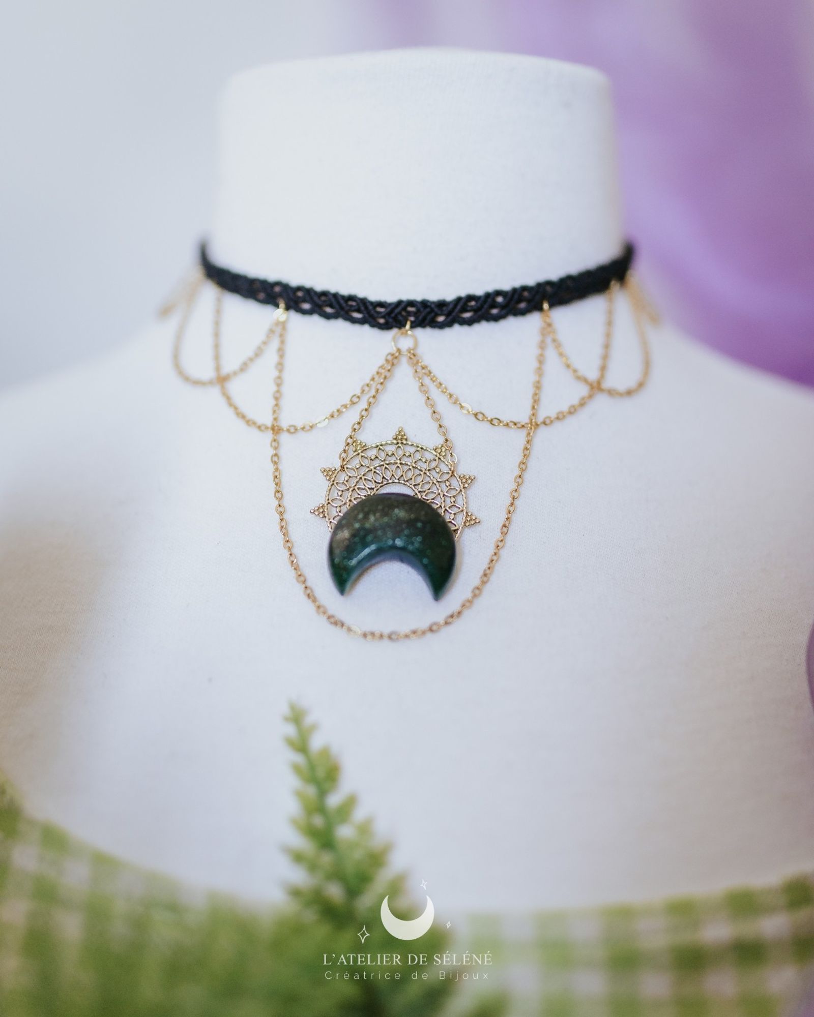 Black choker with green stone , a brass sun and stainless steel chains