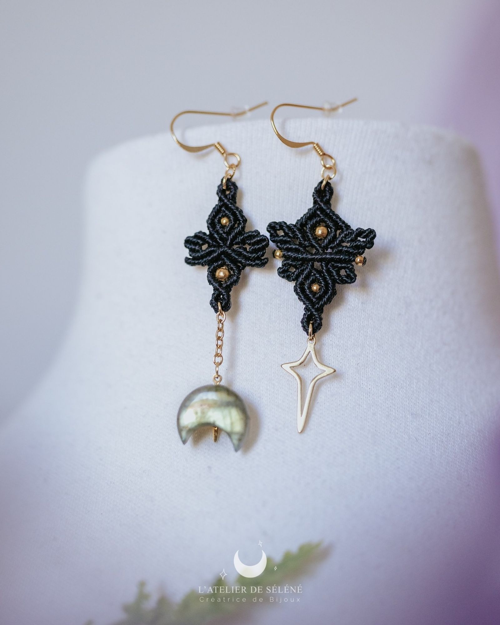 Asymetrical golden Earrings with a labradorit moon and a stainless Steel star pendent. Each earring is made with black wire.