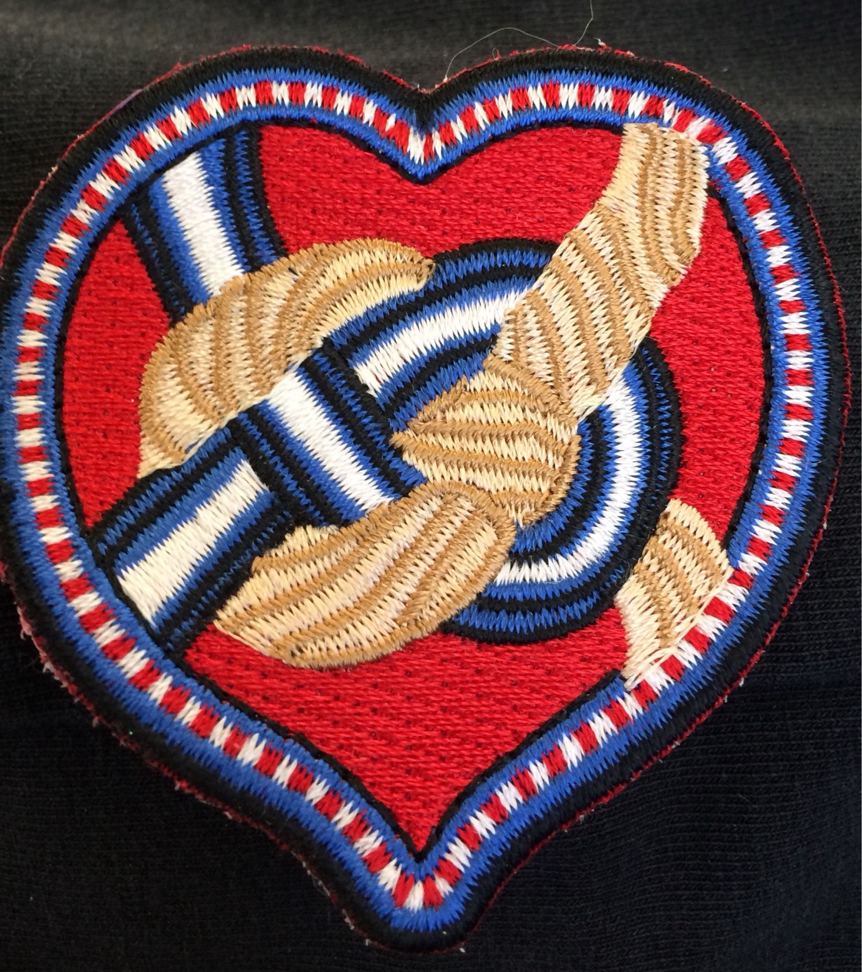 Manufactured patch of my original Rope Pride embroidery. A red heart with a knot tied over it. One half the knot appears to be rope, the other half is black, blue and white, the kink pride colors. I still have some for sale or trade.