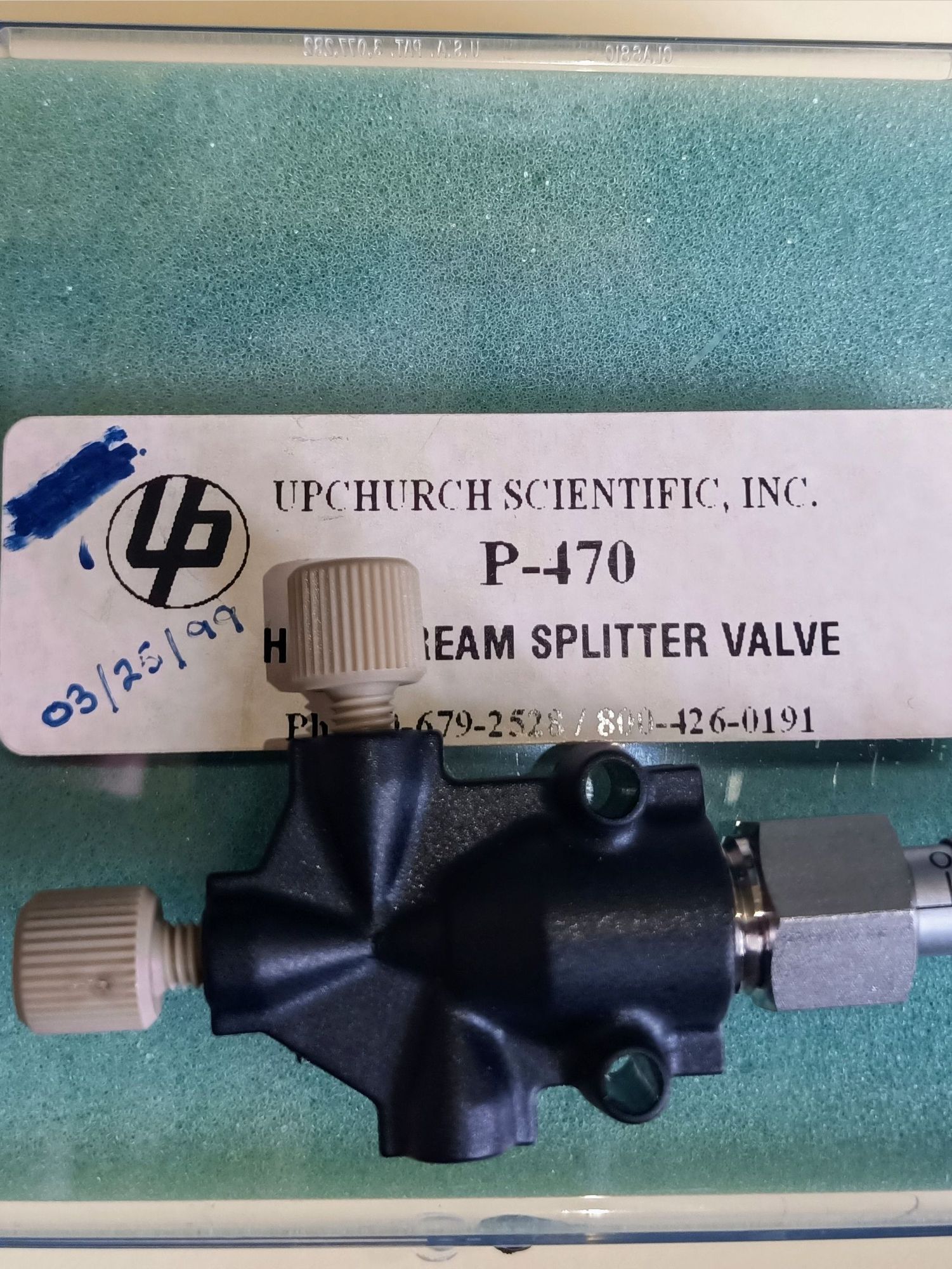 Upchurch Scientific P-470 downstream splitter valve. The image shows the  needle valve laying on top of its original box. Hand-written text at the label "03/26/99".