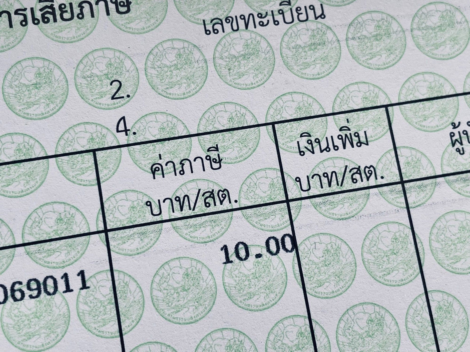 Close-up photo of the page from my scooter registration book, showing the annual road tax fee of 10 baht. The text is in Thai script.