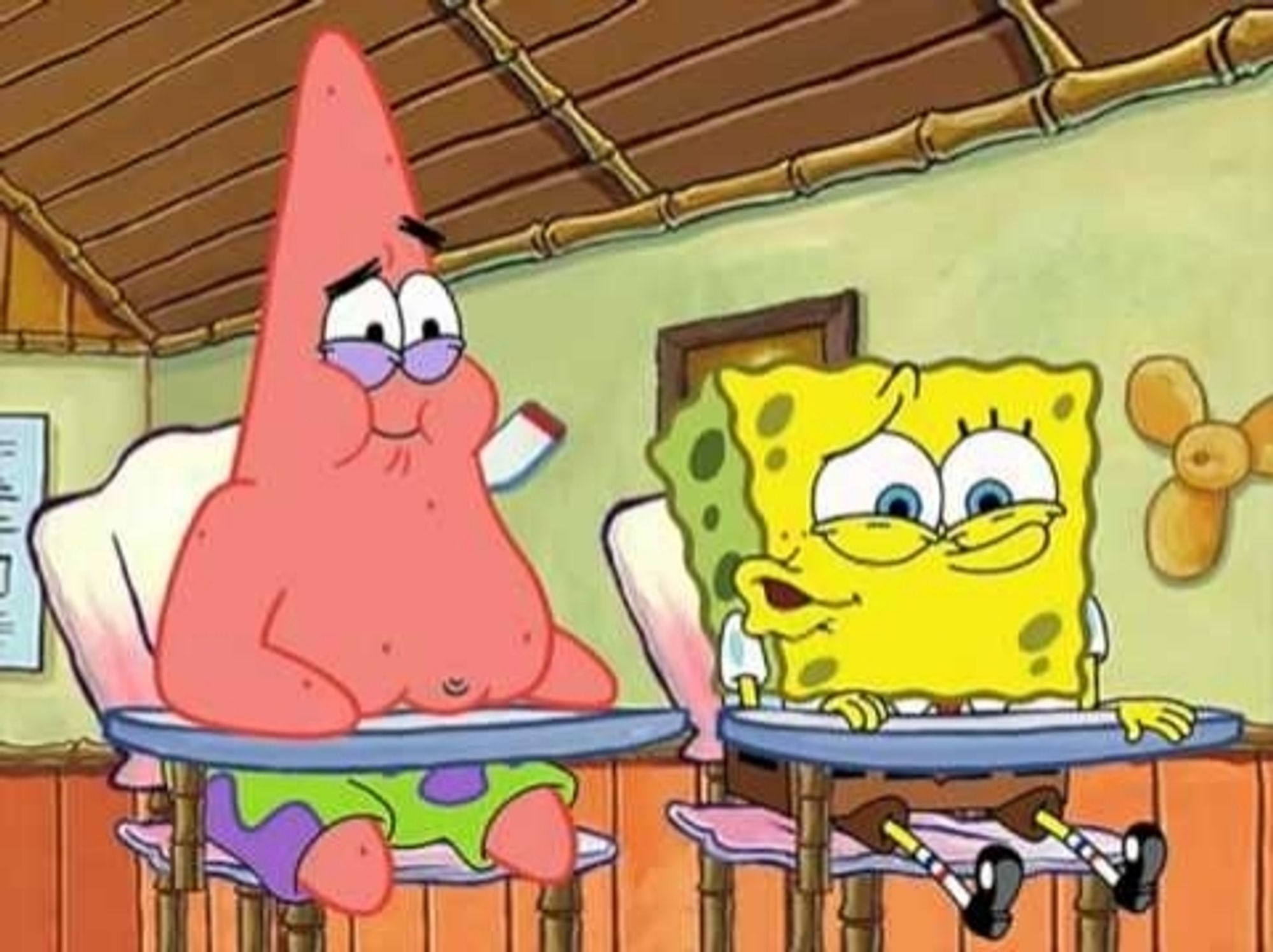 Spongebob whispering to Patrick in boating school