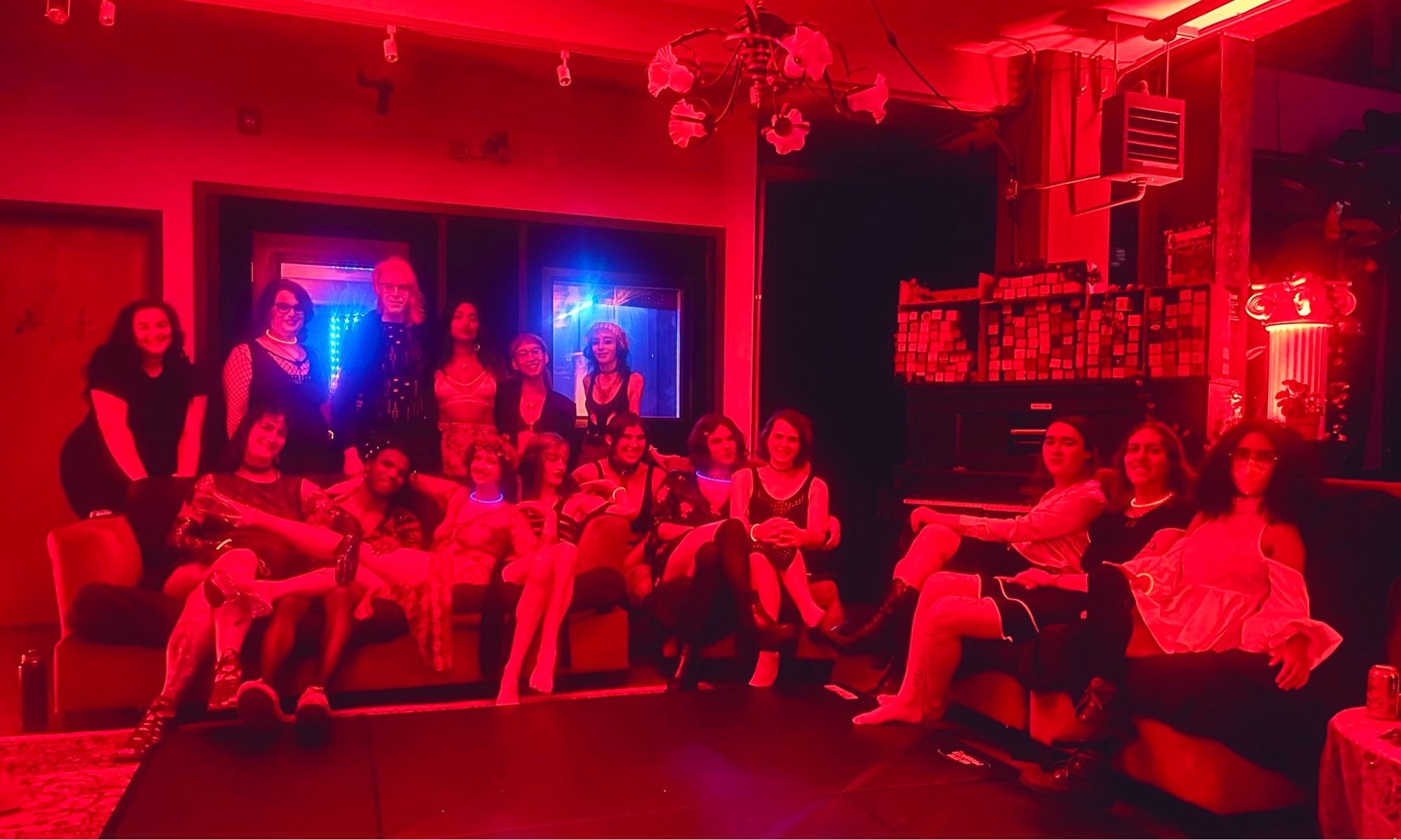 The crew posed on two couches bathed in red before the start of the play party