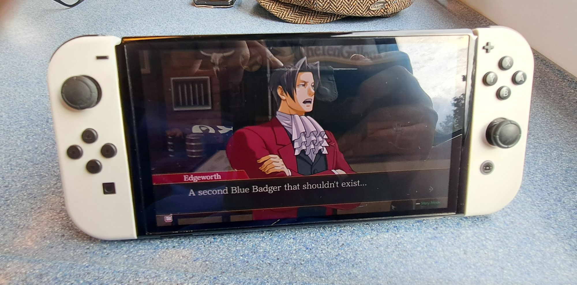 A Nintendo Switch OLED model in tabletop mode playing Ace Attorney Investigations