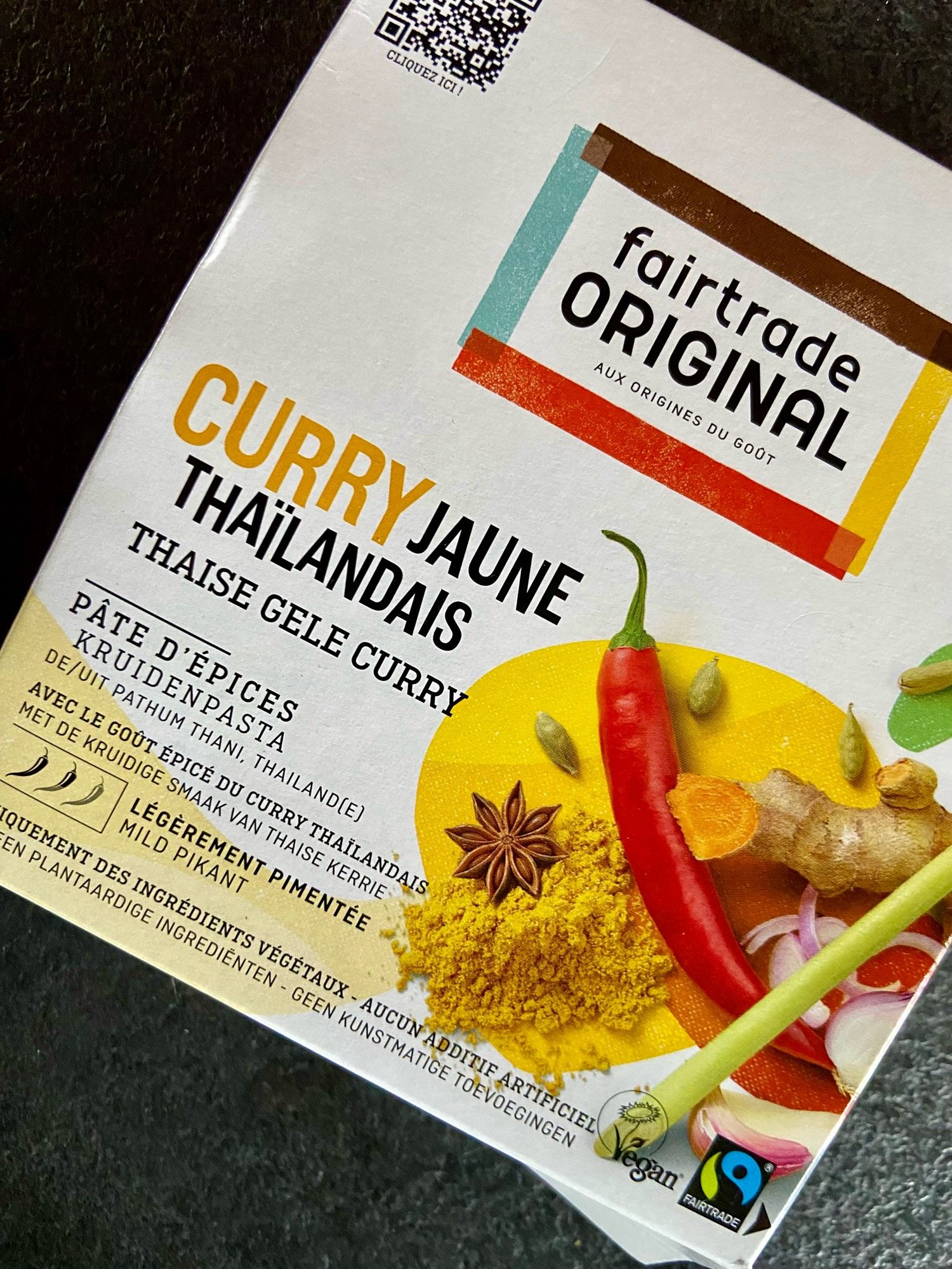 Paquet de curry thaï jaune, avec photo d'un piment rouge, de gingembre, une étoile de badiane, des graines de cardamome.