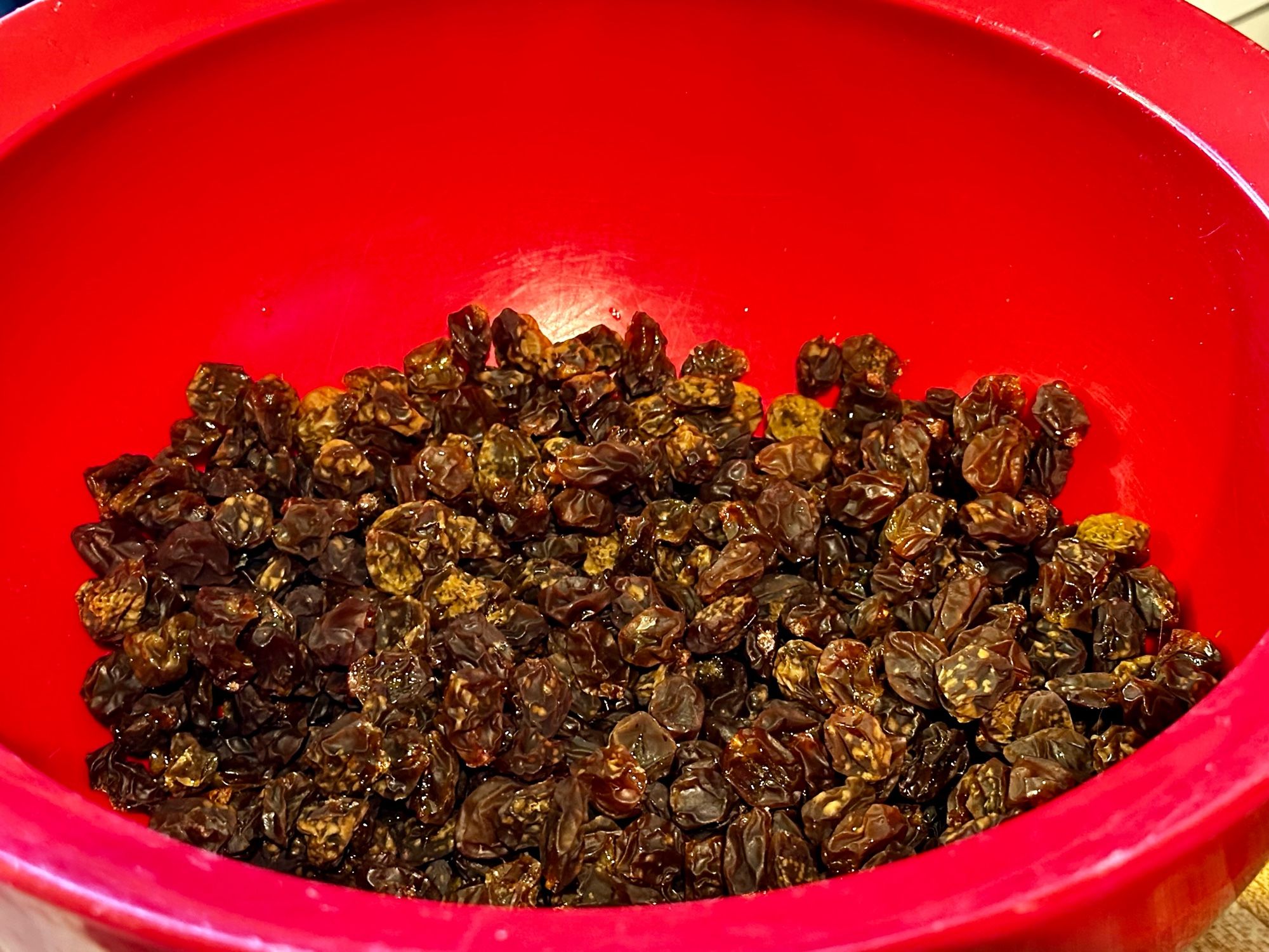 A red bowl filled with small homemade raisins