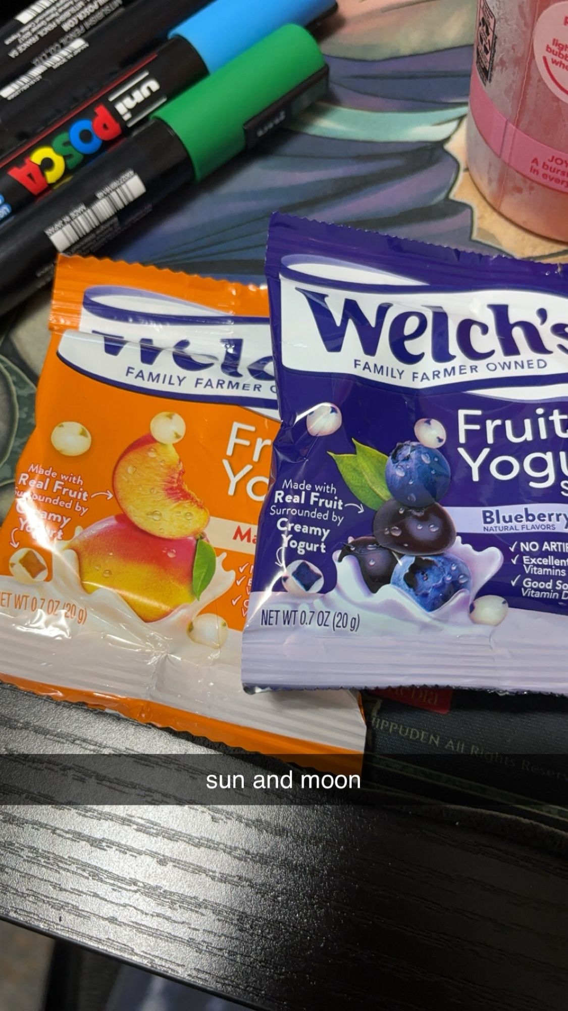 Two packets of Welch’s fruit yogurt snack packs. One is orange and one is blue. There’s a Snapchat text line that reads “Sun and Moon”