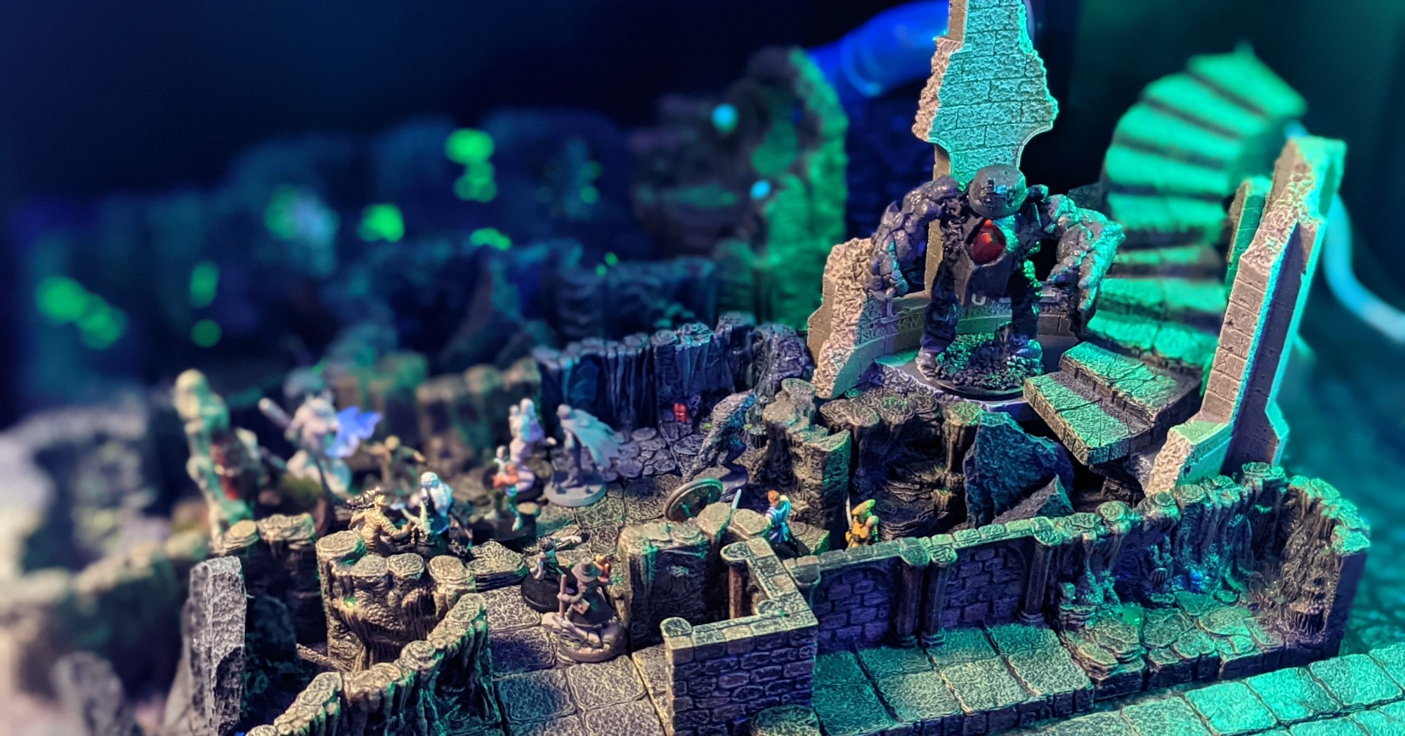 A tabletop miniature set showing the Underdark. With glowing slime in the dark. 