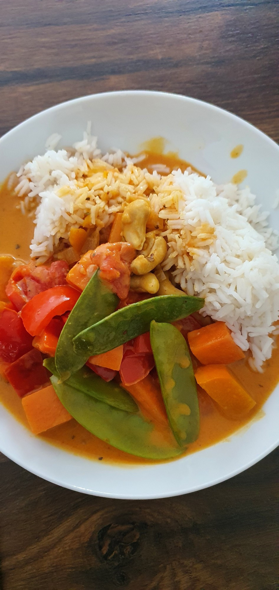 Weißer Teller mit Reis und Kürbis-Süßkartoffel-Paprika-Curry