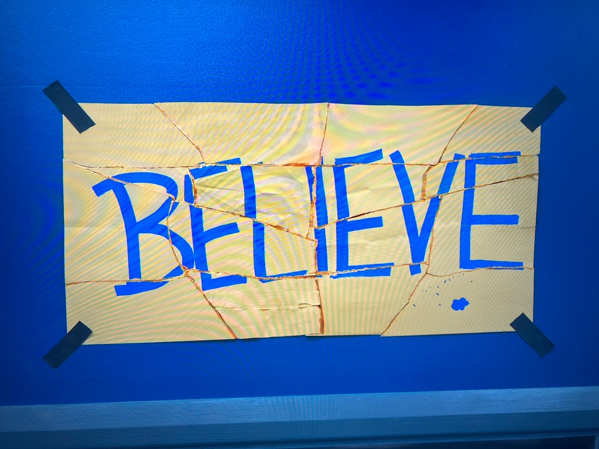 Yellow sign with Believe written in blue