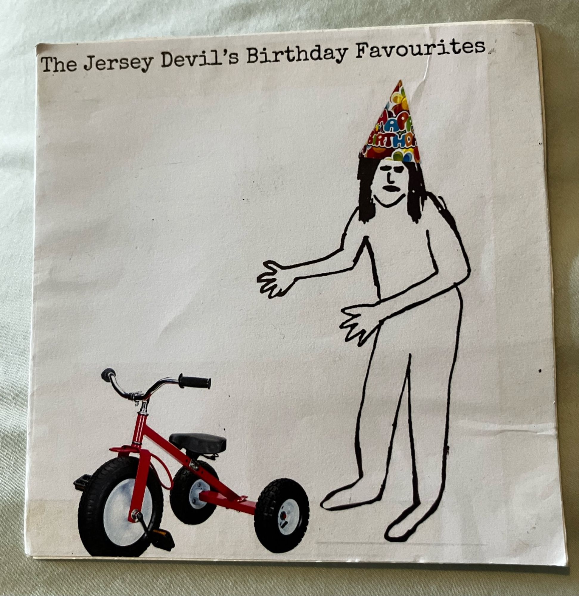 Homemade birthday card featuring the Jersey Devil as seen in an early episode of the X-Files, but with a party hat and a trike.