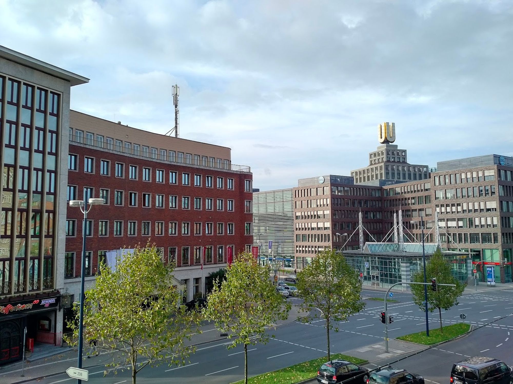 Blick auf das U-Turm der ehemaligen Dortmunder Union. Davor eine Kreuzung, Baeume und ein grosser Bau auf der anderen Strassenseite