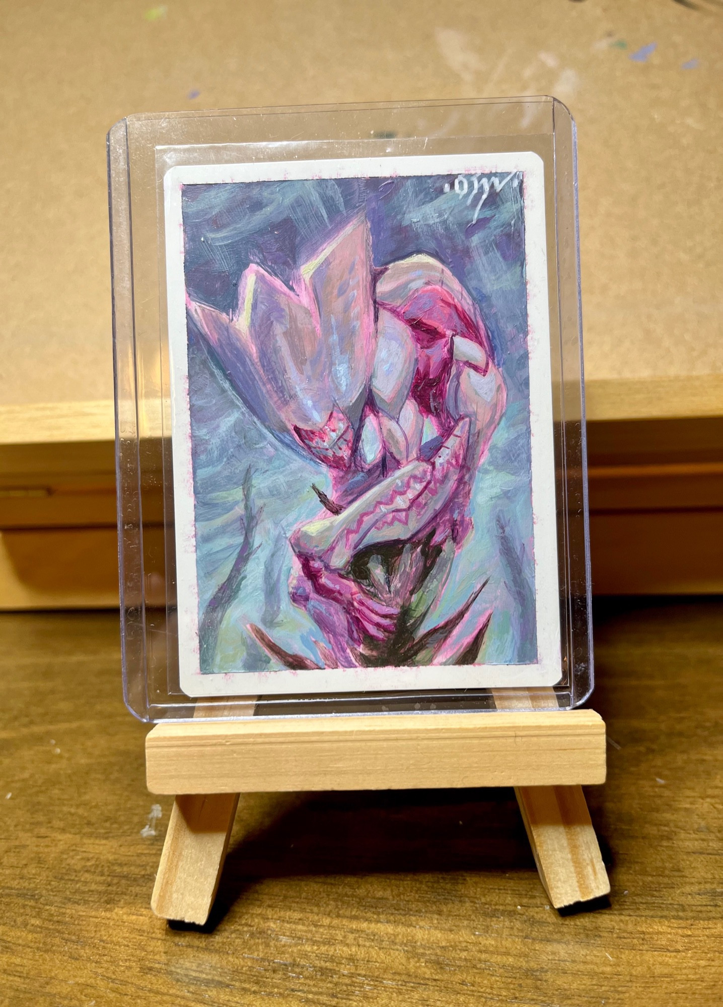 An acrylic painting of a Phyrexian mite on an artist proof of a Mite token. 