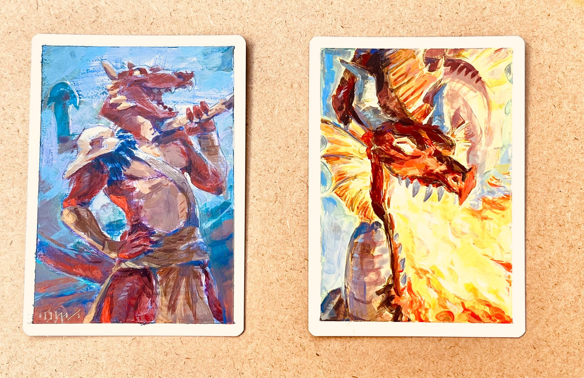 A pair of acrylic paintings of a kobold on the left and a red dragon on the right. 