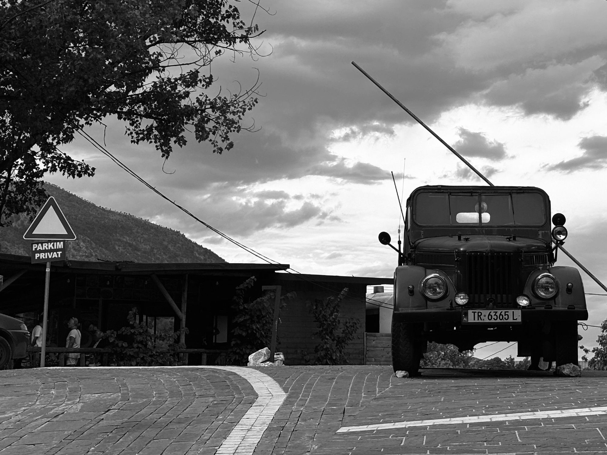 Black-and-white photo of a Soviet-made military off-roader parked in Tepelenë, Albania