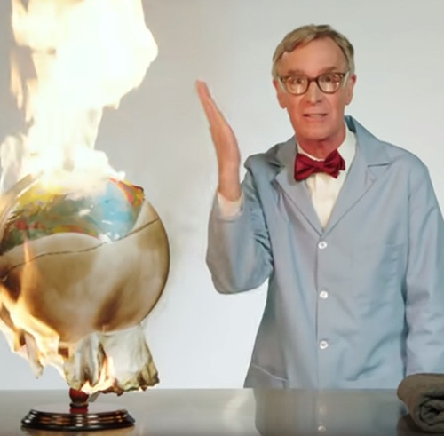 Photo of Bill Nye with a globe on fire.