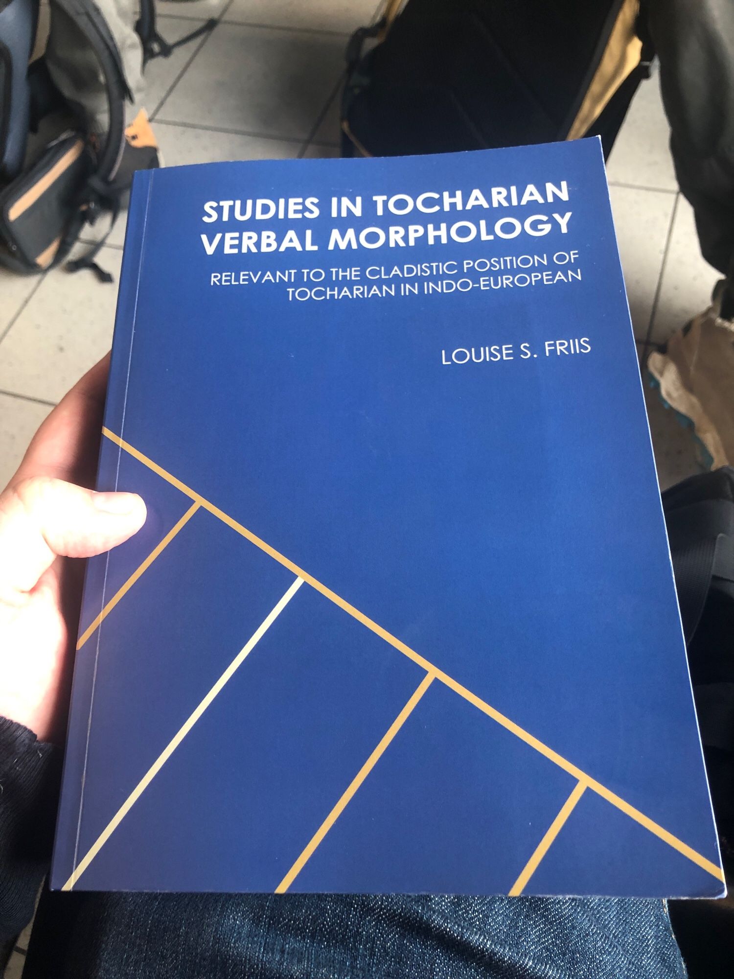 The dissertation in question: Studies in Tocharian Verbal Morphology Relevant to the Cladistic Position of Tocharian in Indo-European, by Louise S. Friis. The cover is blue and there is a branching structure on a cover with blue background.