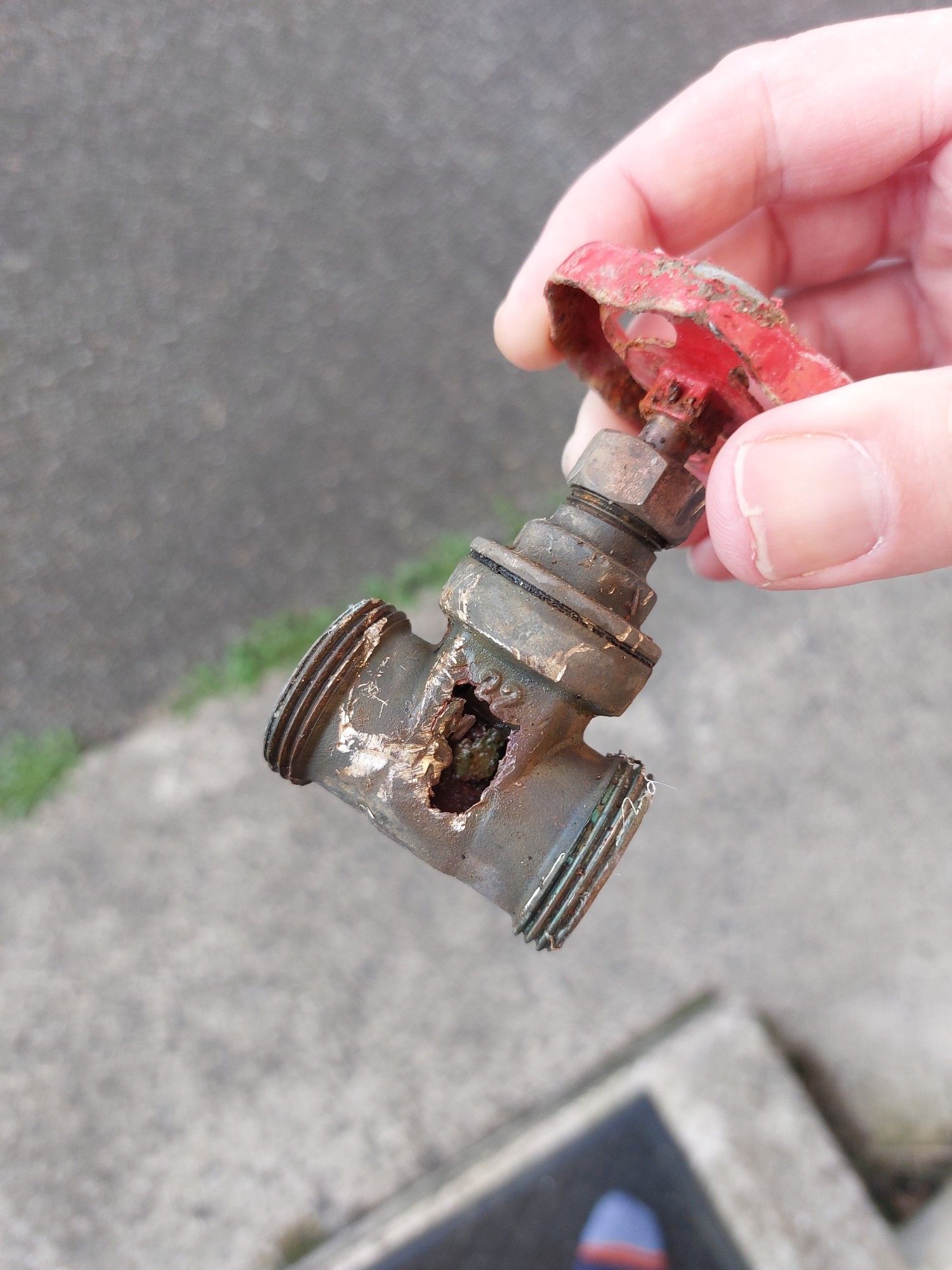 Photo of a metal valve with a great big corroded hole in the side.