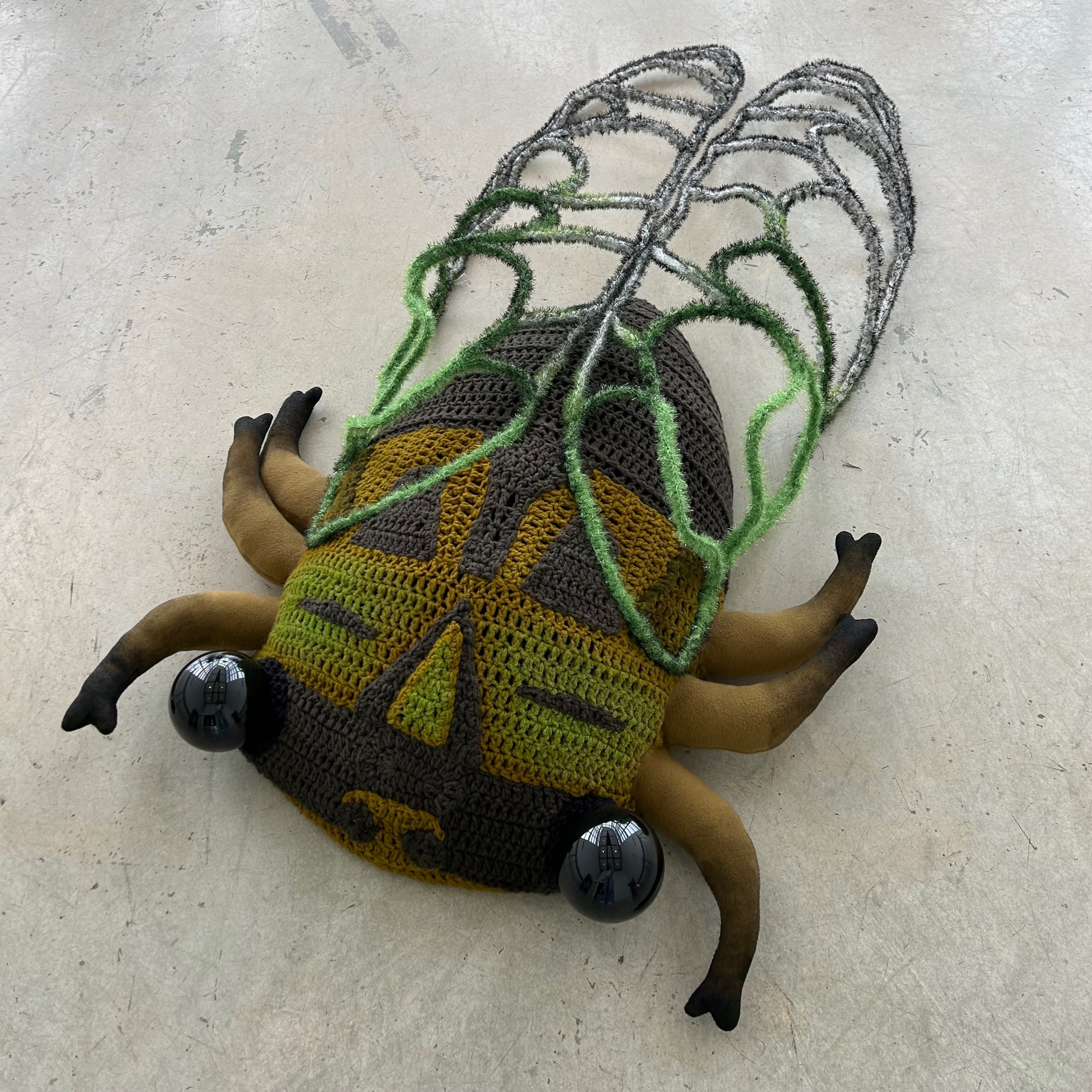 giant cicada sculpture on ground