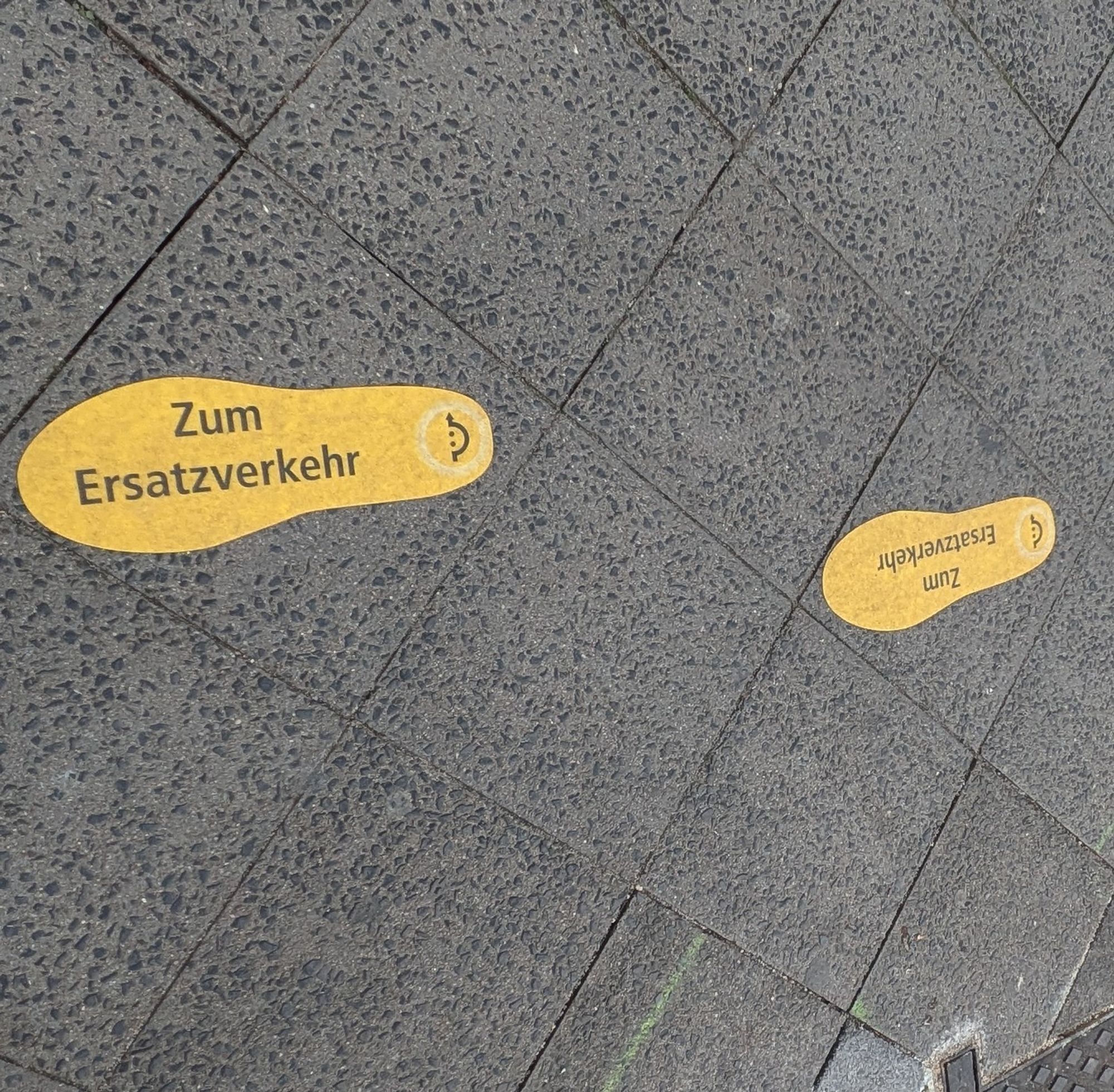 Auf dem Gehweg gelbe Fußspuren aufgeklebt: Zum Ersatzverkehr.