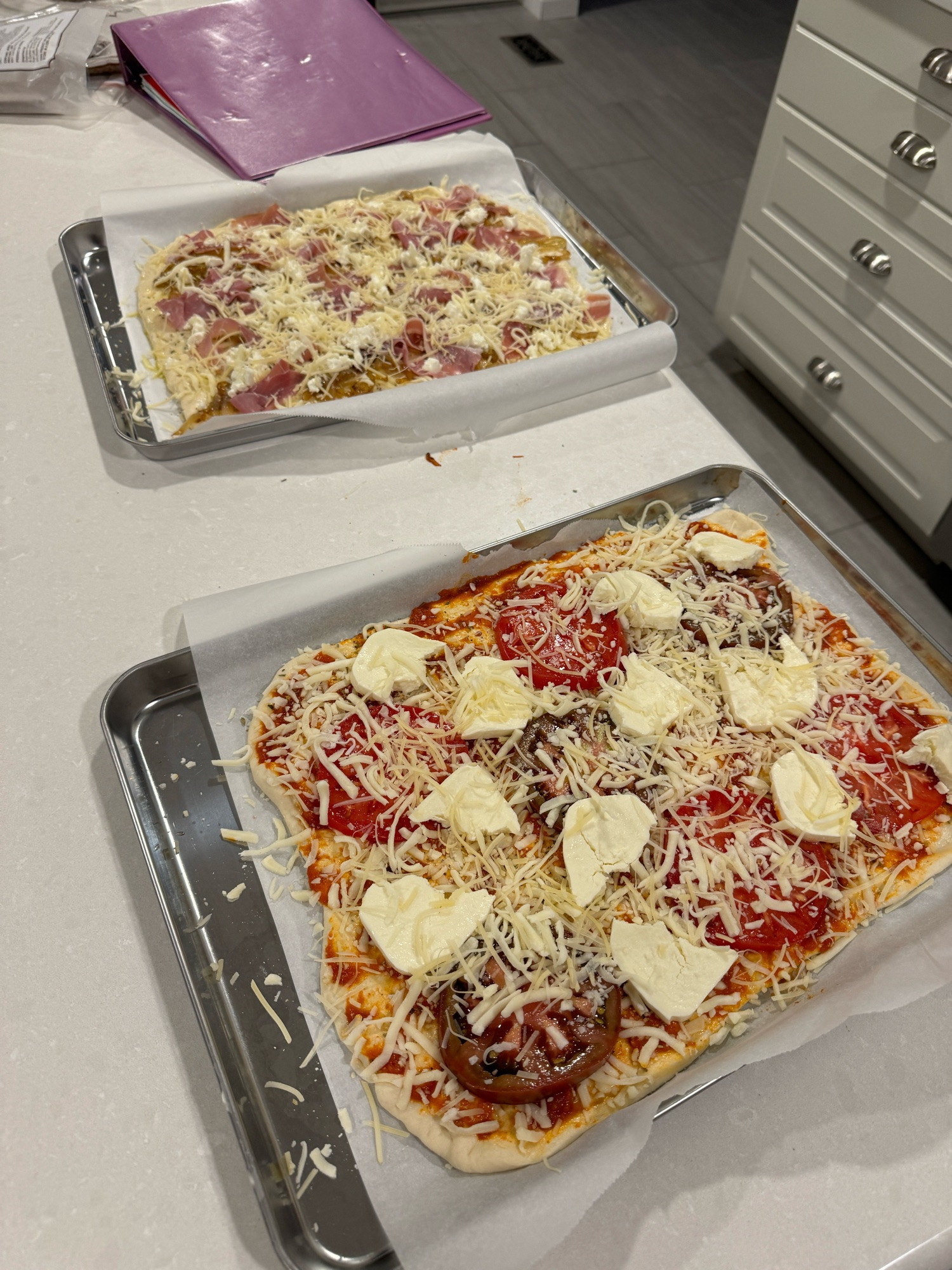 Two pizzas ready to go in the oven