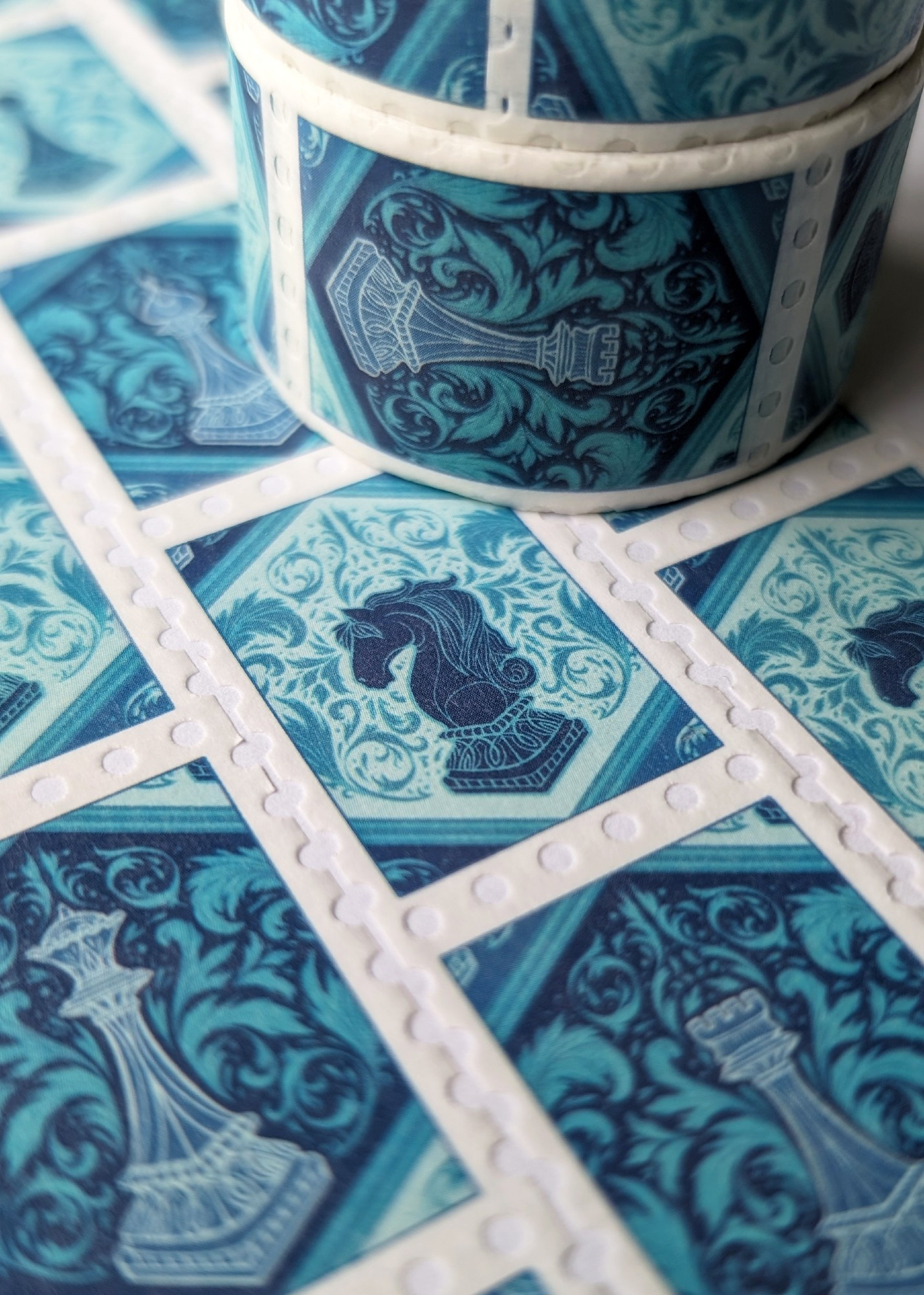 A photograph of rolls of washi tape with illustrations of blue chess pieces on it.