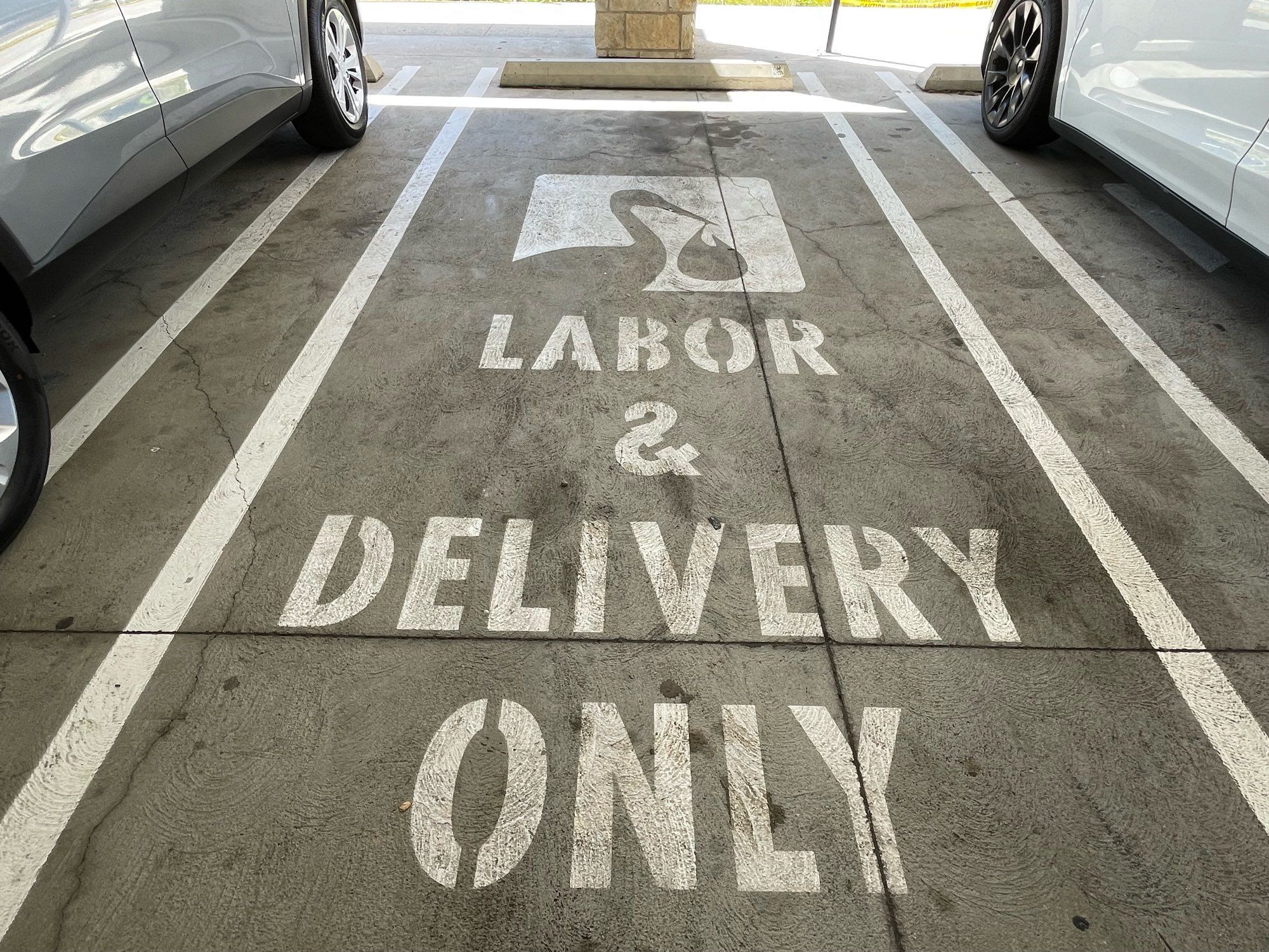 Painted parking says LABOR & delivery only with a picture of a stork