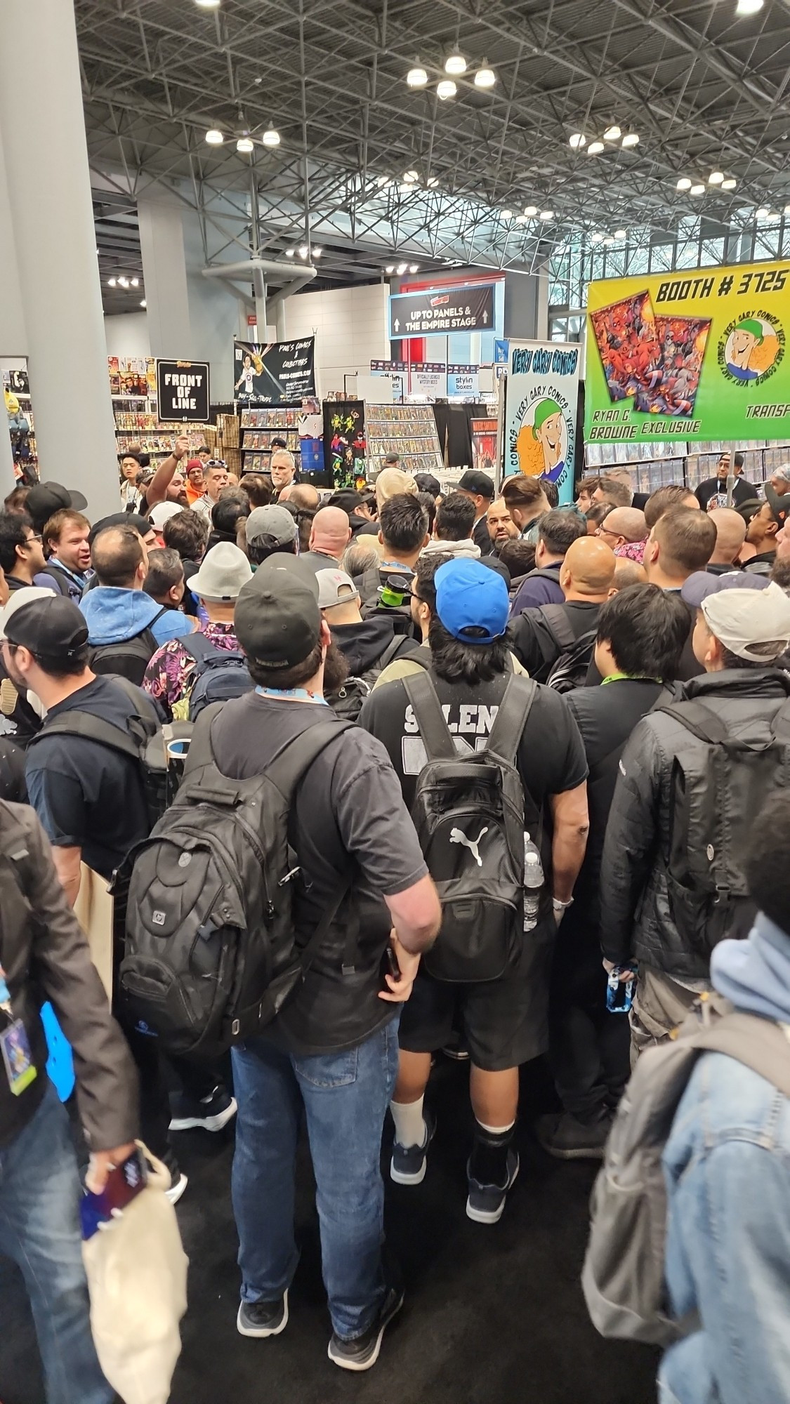 A bunch of guys fighting in a line to get an exclusive comic at New York Comicon.