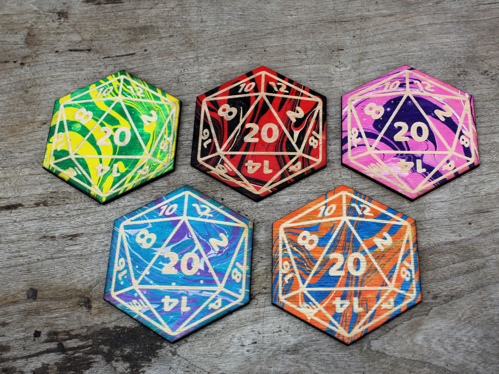 A set of 5 coasters engraved to look like D twenties and the painted with marble colors, yellow and green, red and black, pink and purple, orange and blue, and teal and purple