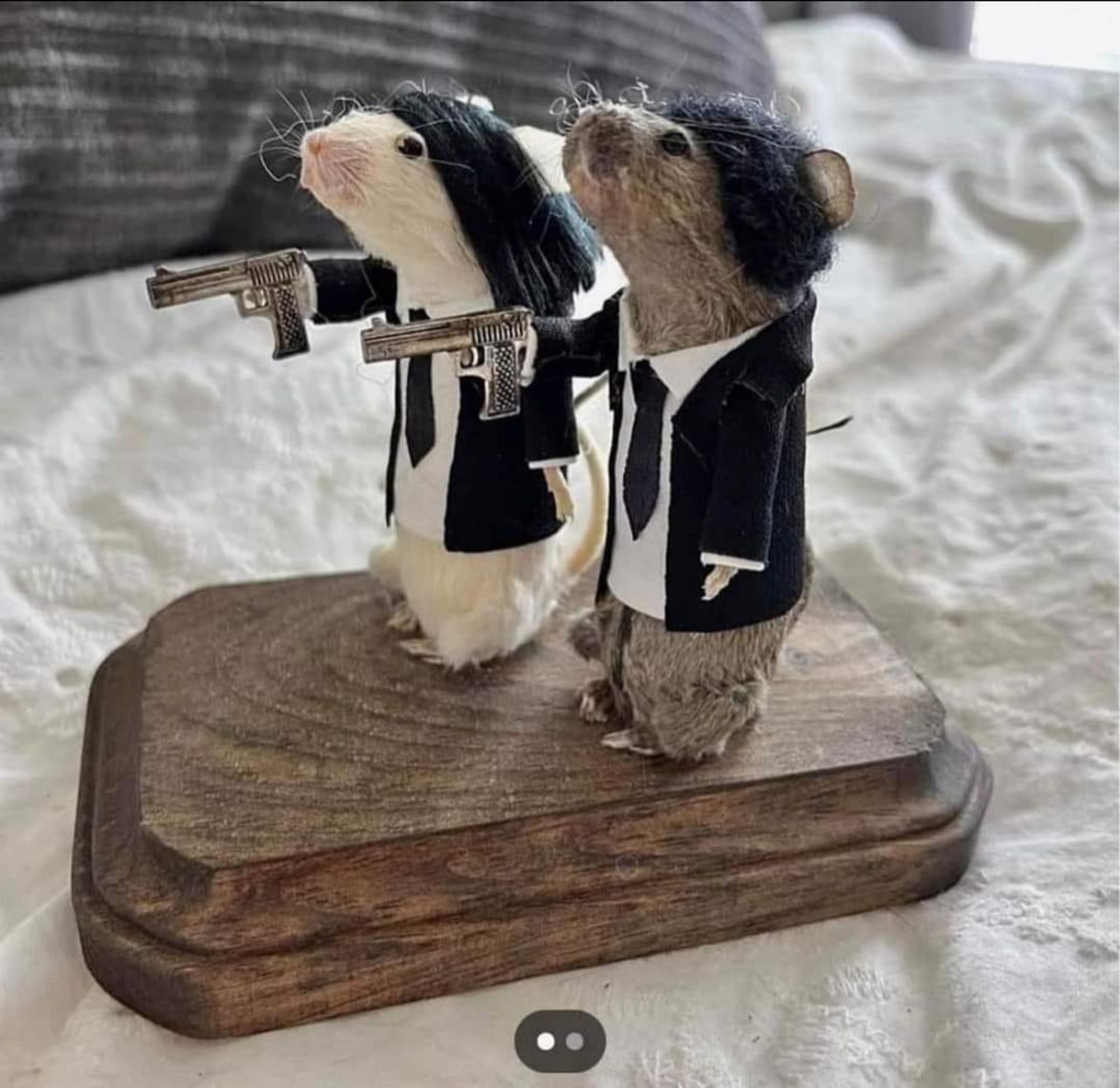 Two taxidermied mice on a wooden plank dressed up like the main characters from Pulp Fiction.