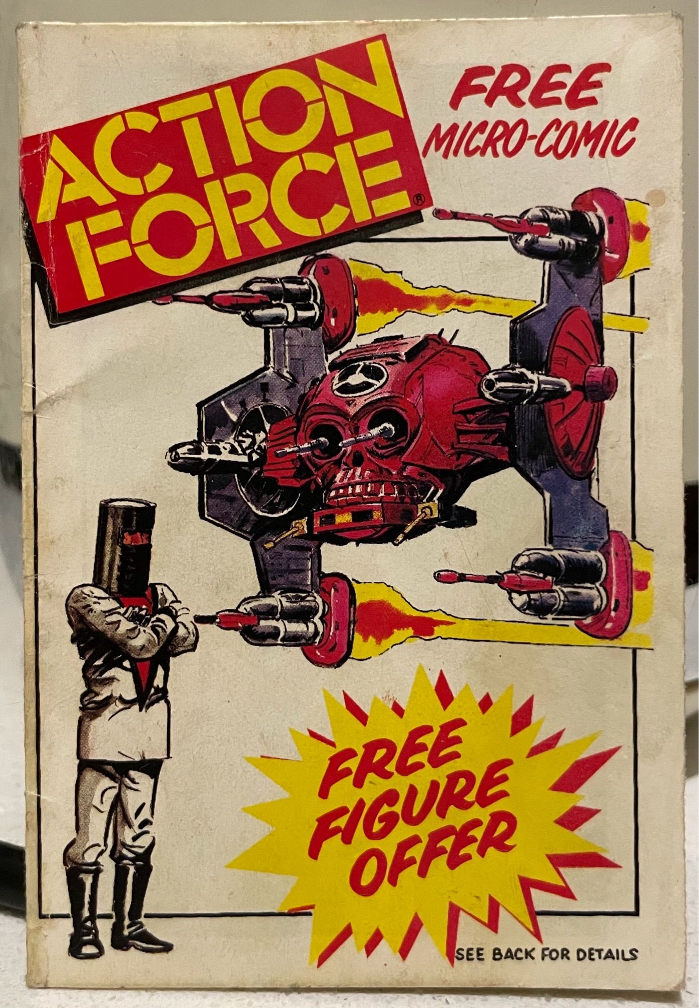 The image features a vintage comic book cover titled "Action Force," labeled as a "Free Micro-Comic." It depicts a red, skull-shaped vehicle with weapons, alongside a character in a black helmet and white suit. A starburst graphic prominently states Free Figure Offer.