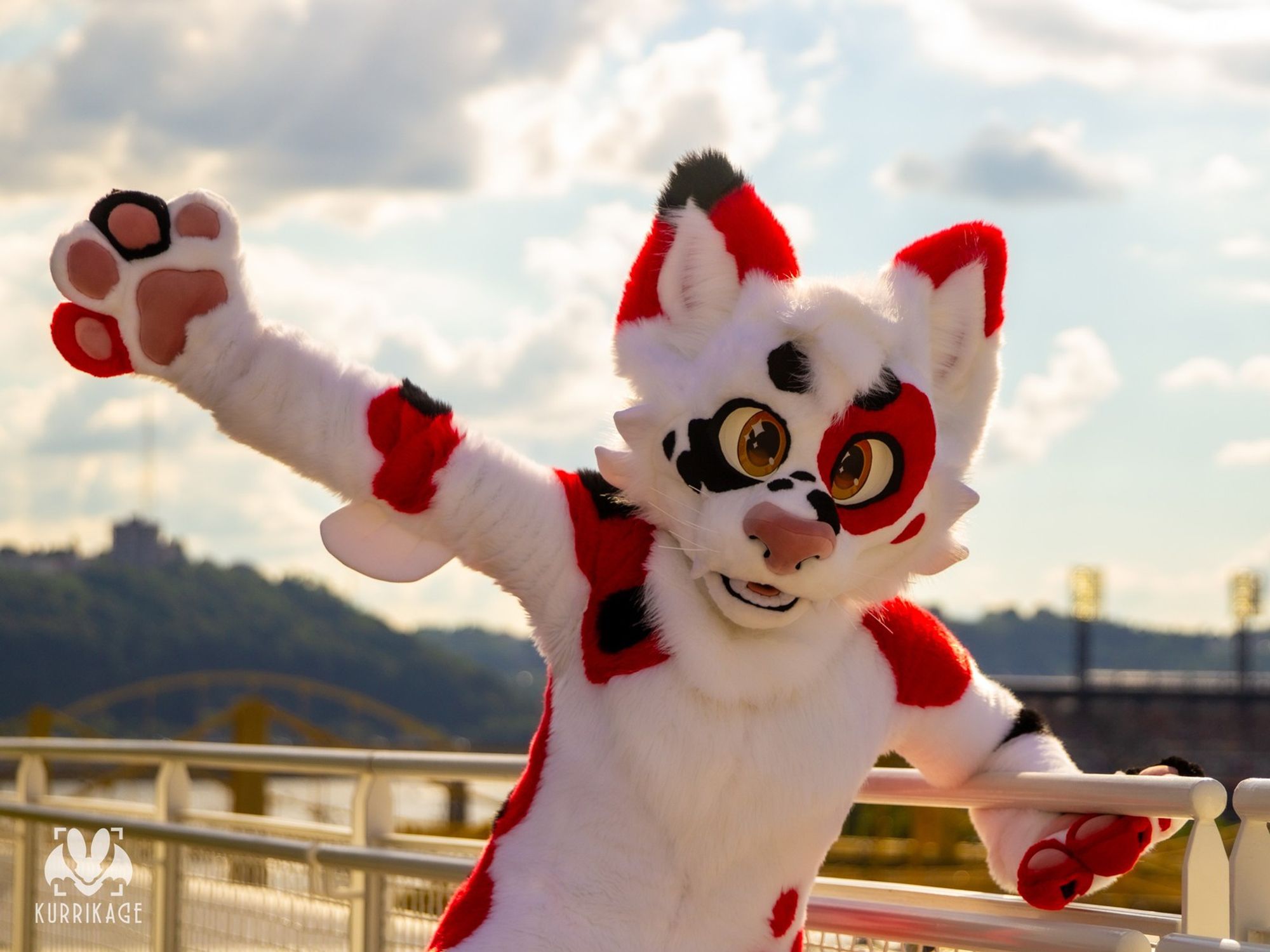 A koi colored cat fursuit holding onto a railing.