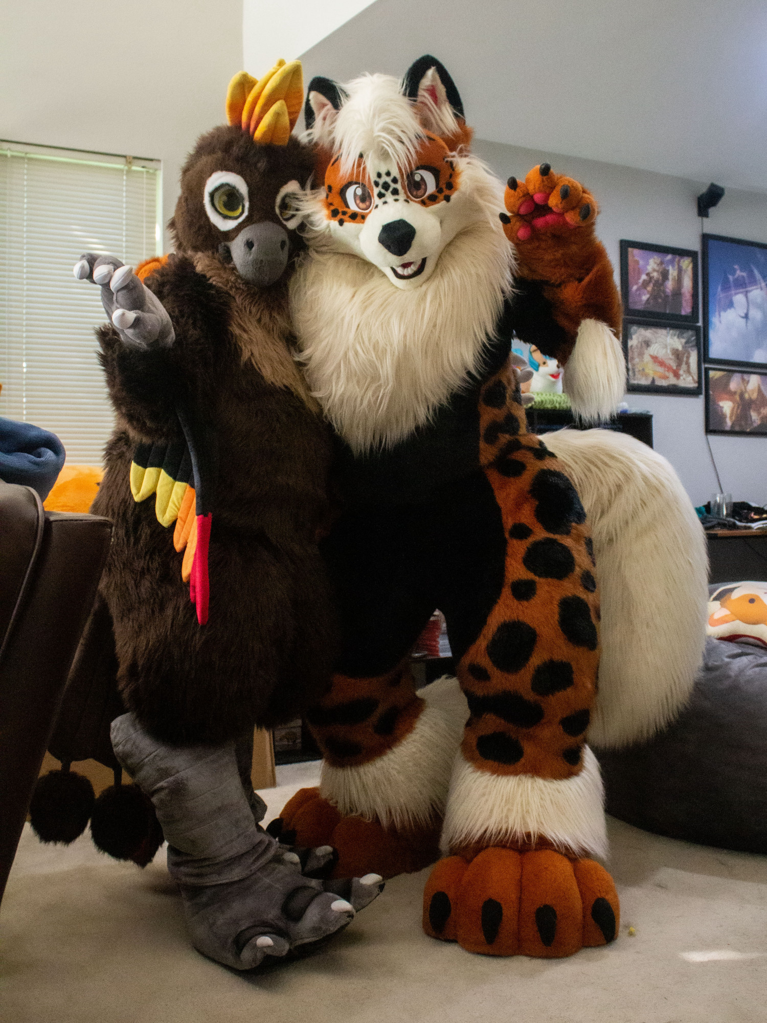 A phoenix and an arcanine fursuit standing together and posing.