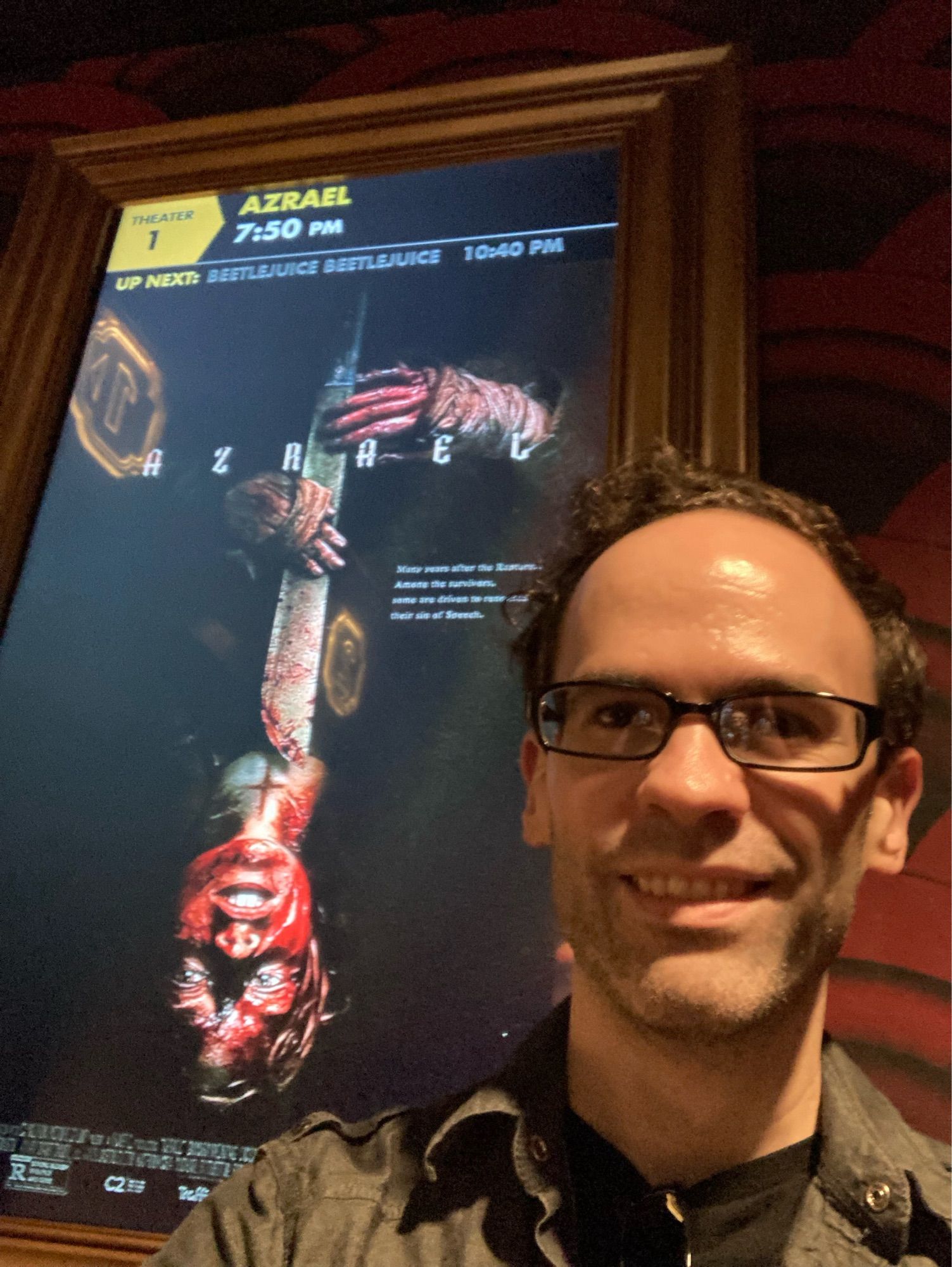 Selfie in front of the movie poster for Azrael at Alamo Drafthouse