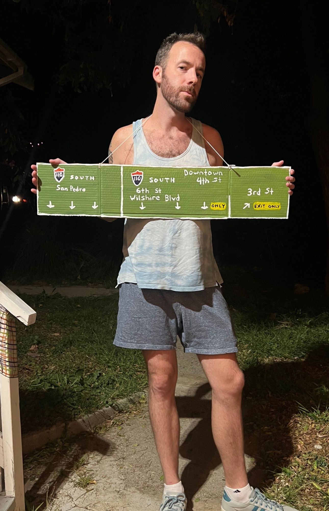 drunk white guy wearing a hand-painted sign of all the downtown exits at the 110 freeway